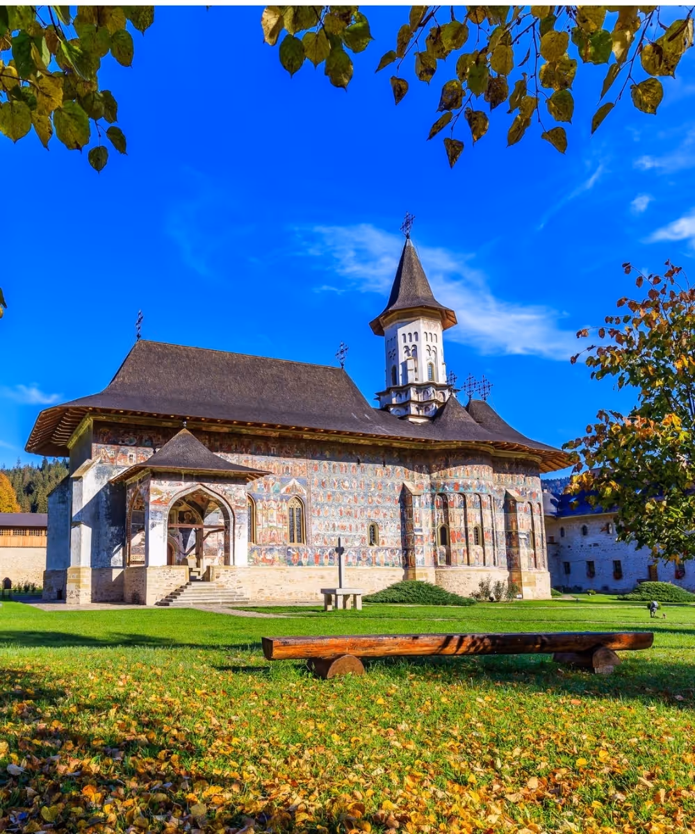 The historic Sucevita Painted Monastery in Bucovina, Romania, displaying detailed exterior wall frescoes.