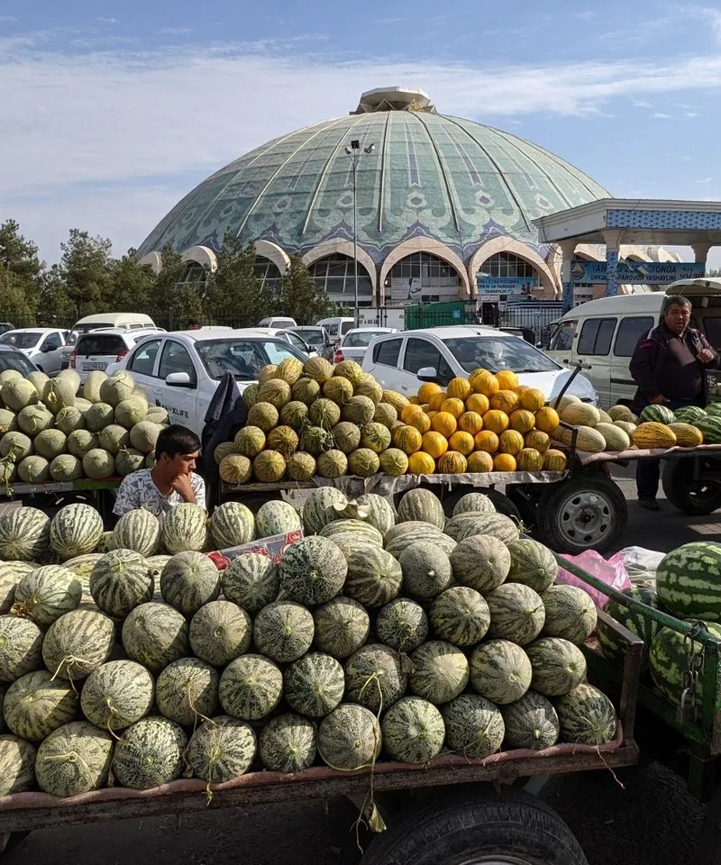 Watermelon vendors outside the large turquoise dome of Chorsu Bazaar in Tashkent, Uzbekistan.