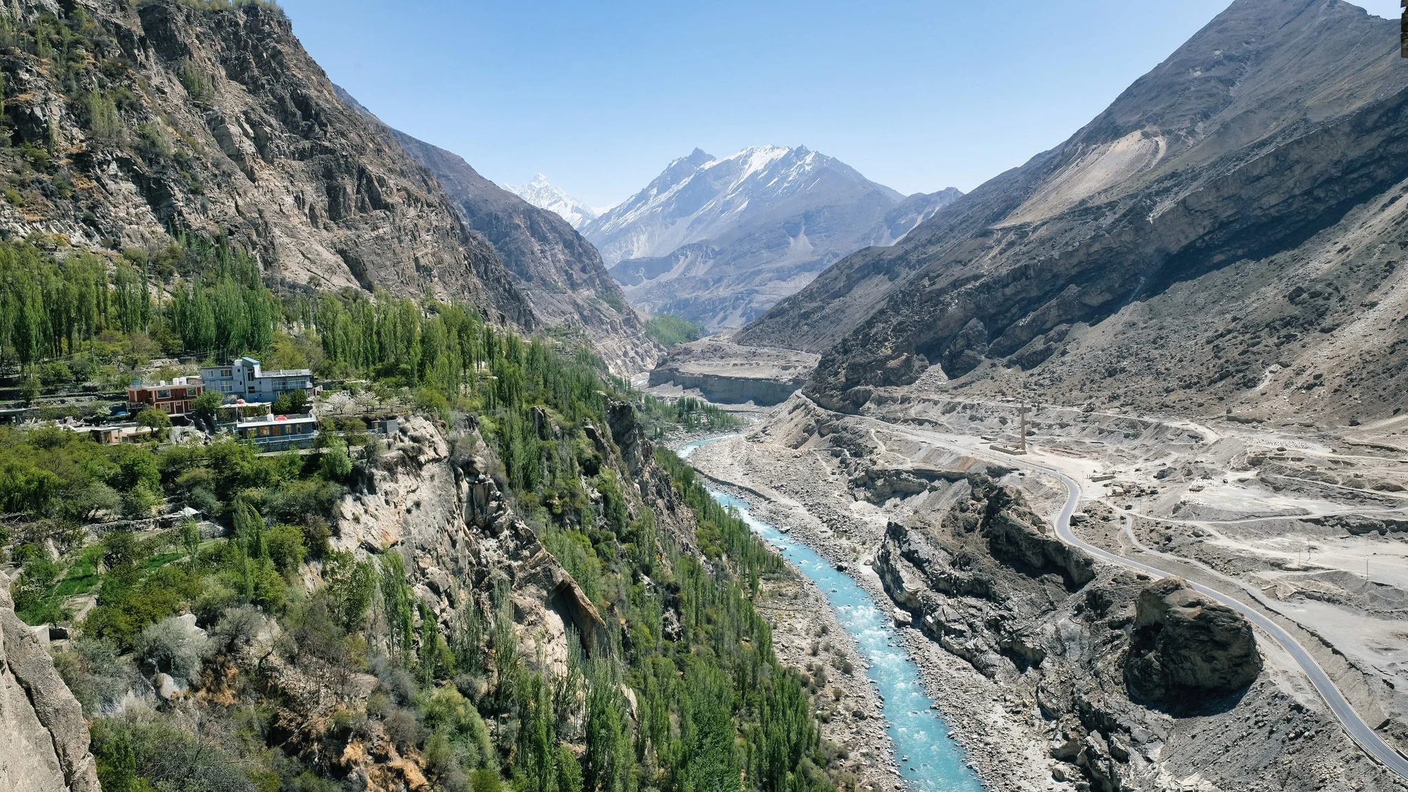Aerial view of Hunza River running beside Karakoram Highway through dramatic rock valleys.