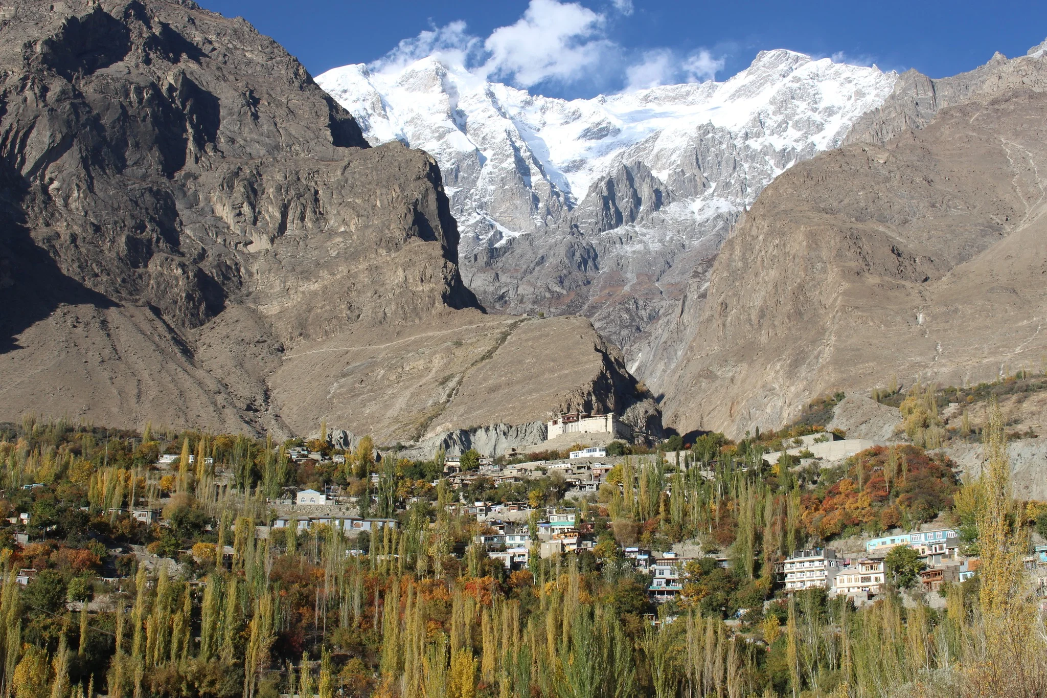 Towering Ultar Peak and Baltit Sar rise behind Hunza’s fall-colored village.