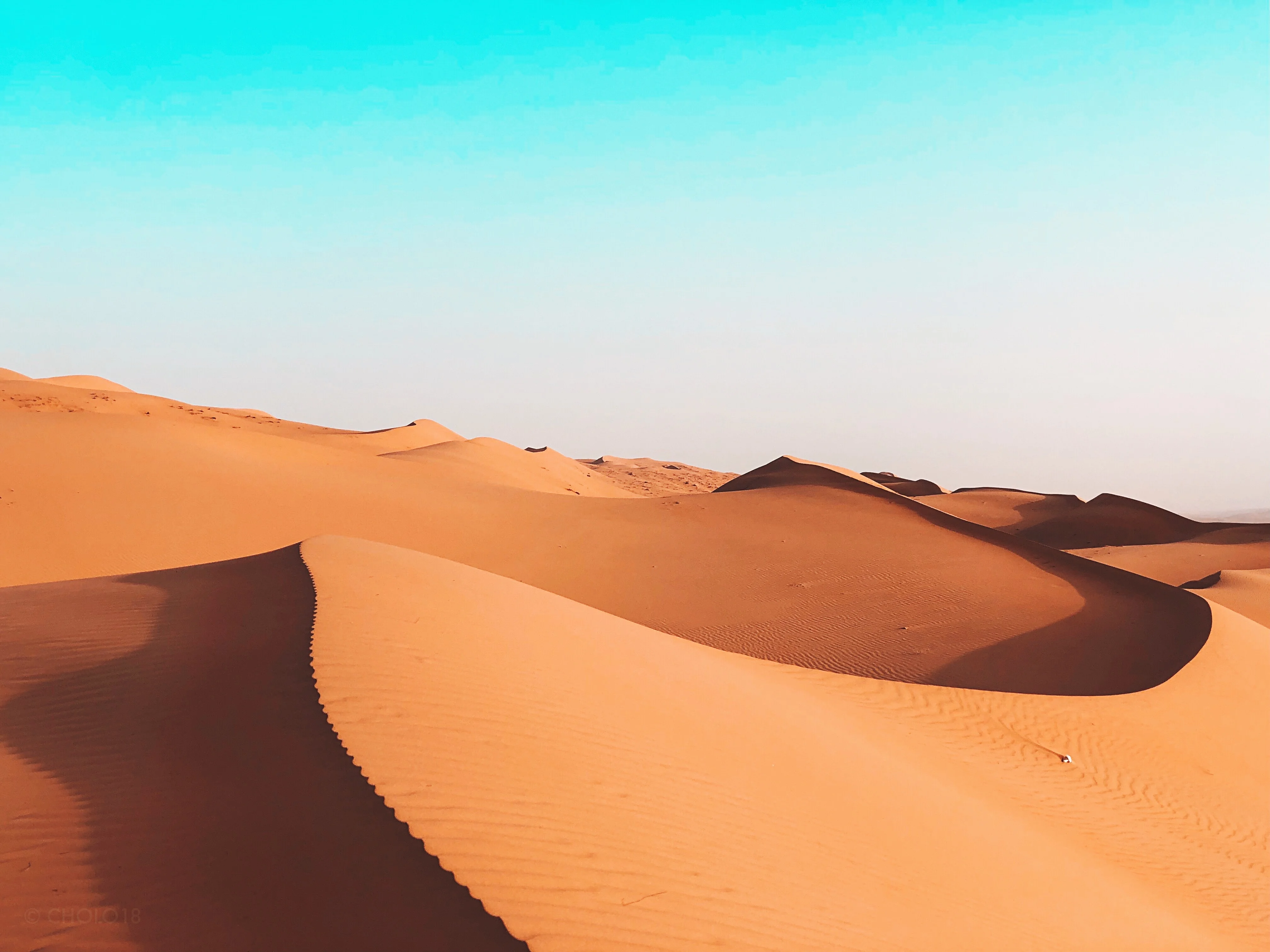 Golden sand dunes under bright sky in Sharqiyah desert on an Oman tour.