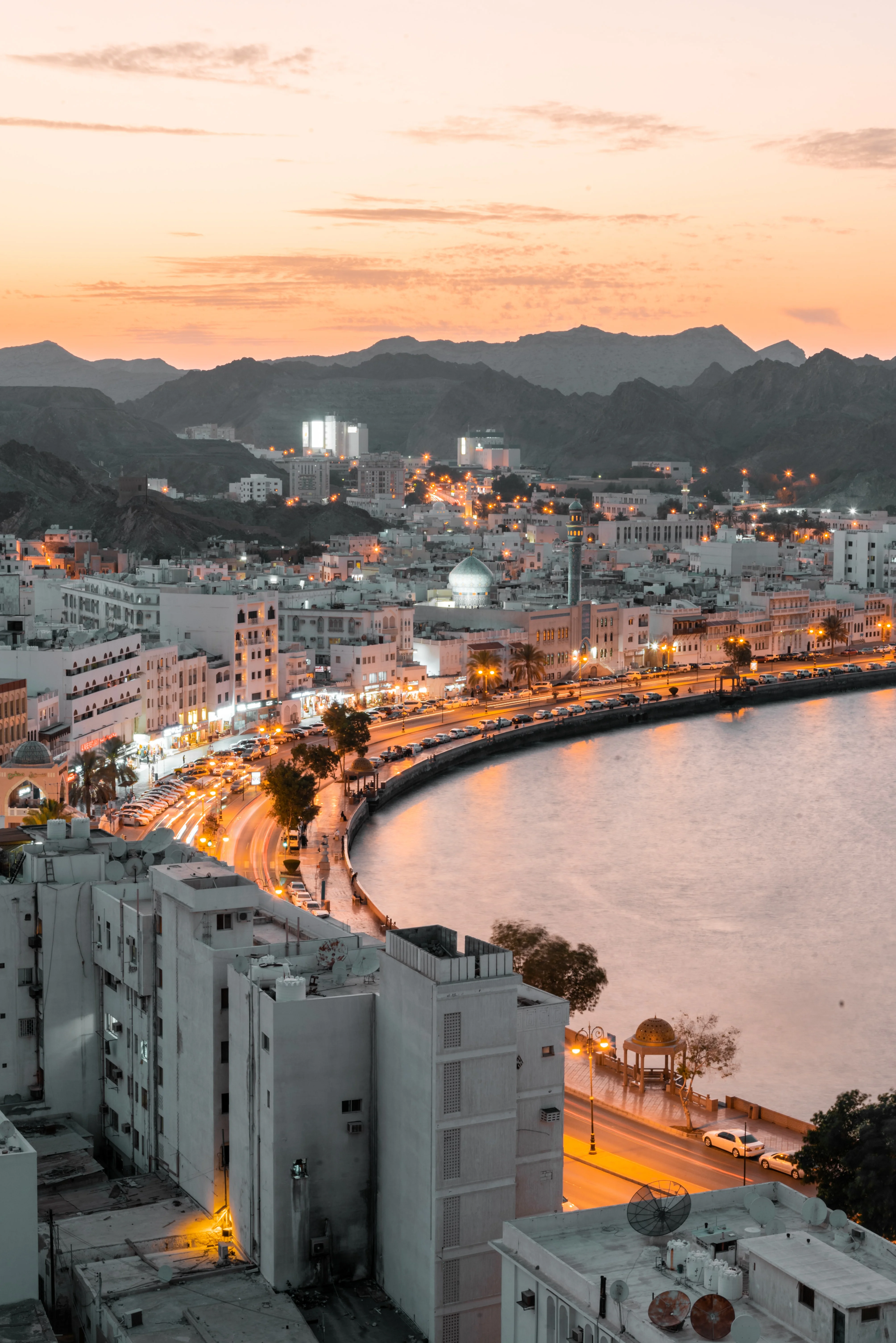 Sunset view of Mutrah Corniche skyline and waterfront on an Oman tour.
