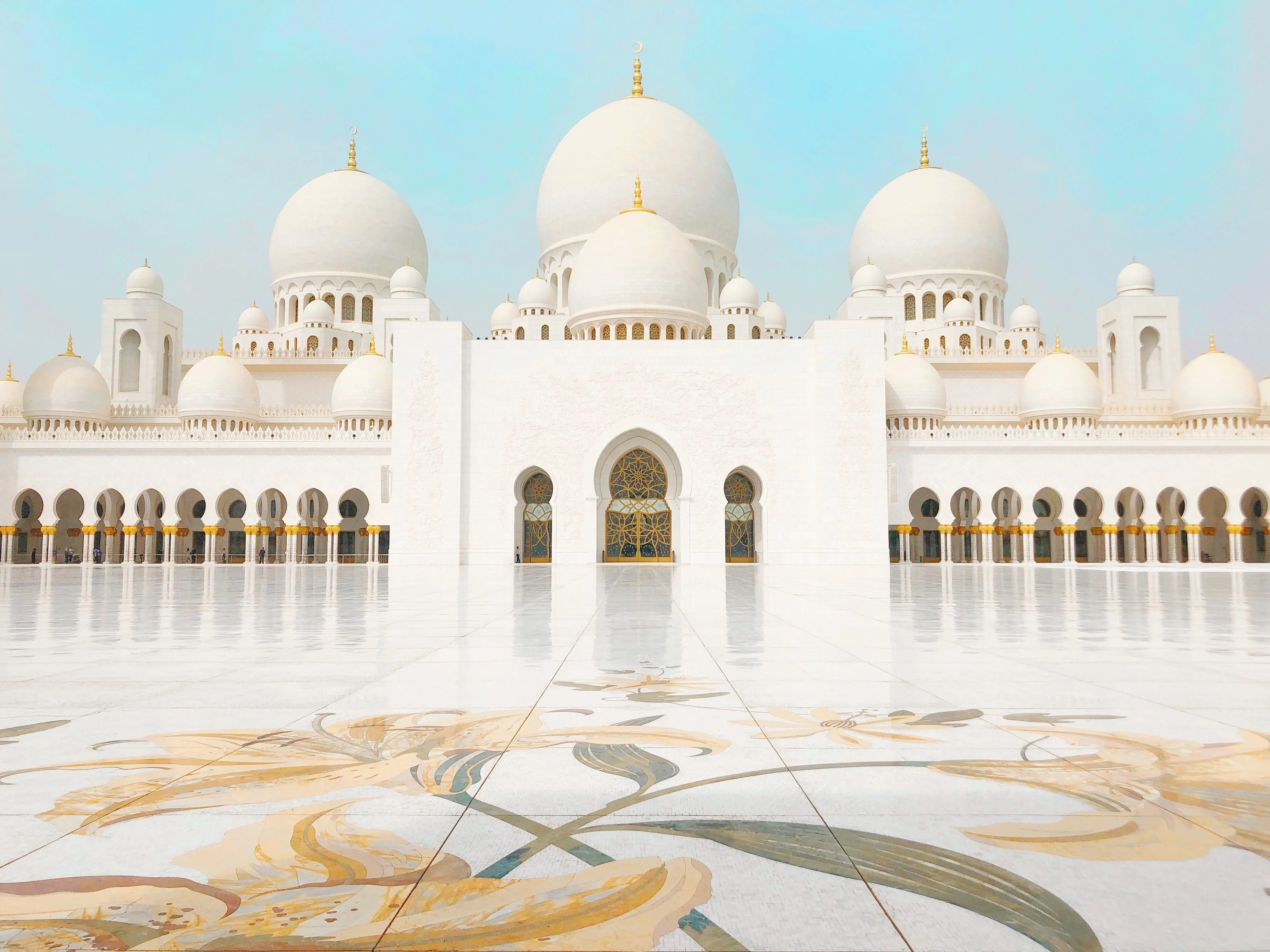 White domes and floral courtyard of Sheikh Zayed Grand Mosque