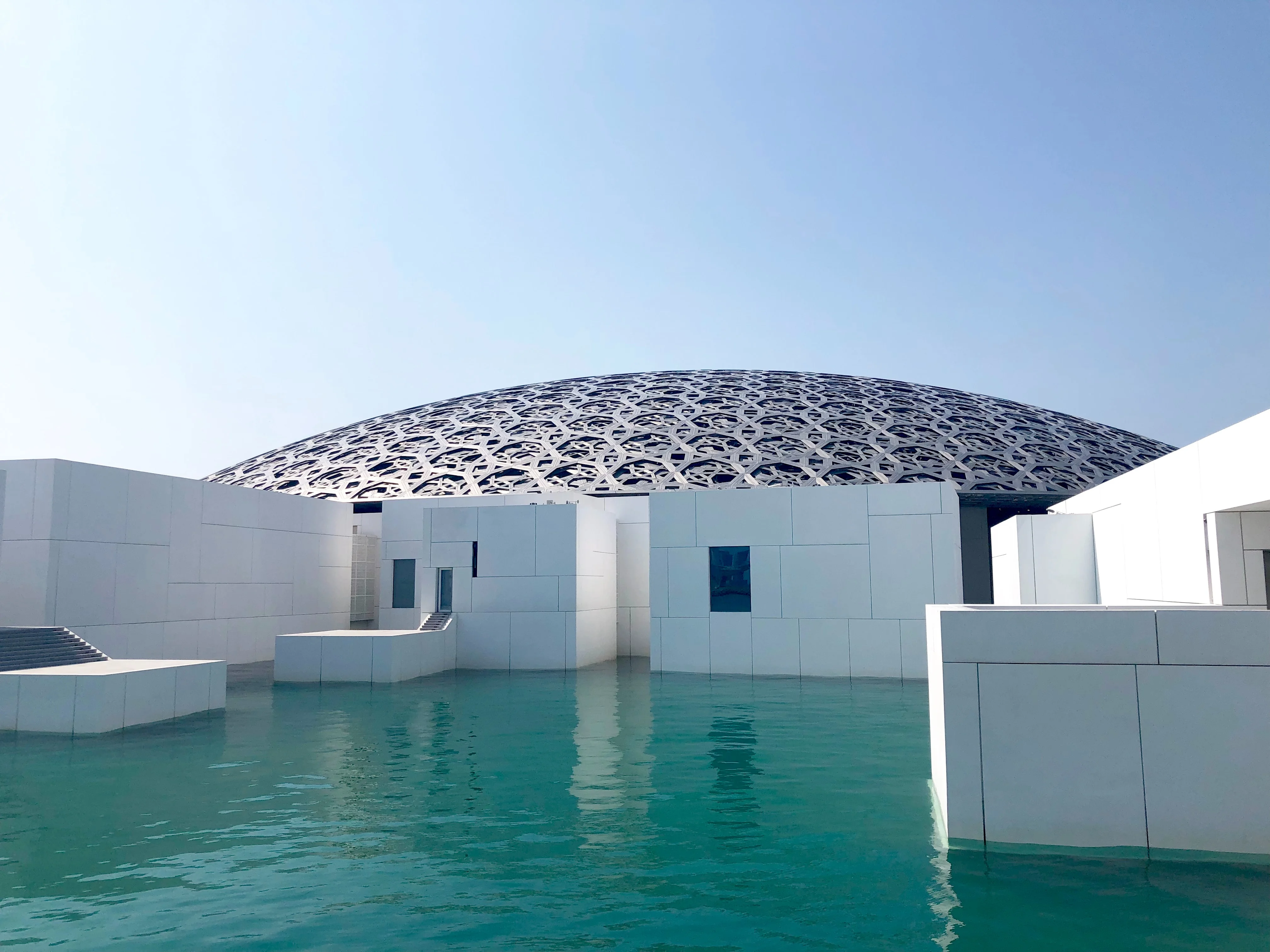 Modern Louvre Abu Dhabi dome and turquoise waters