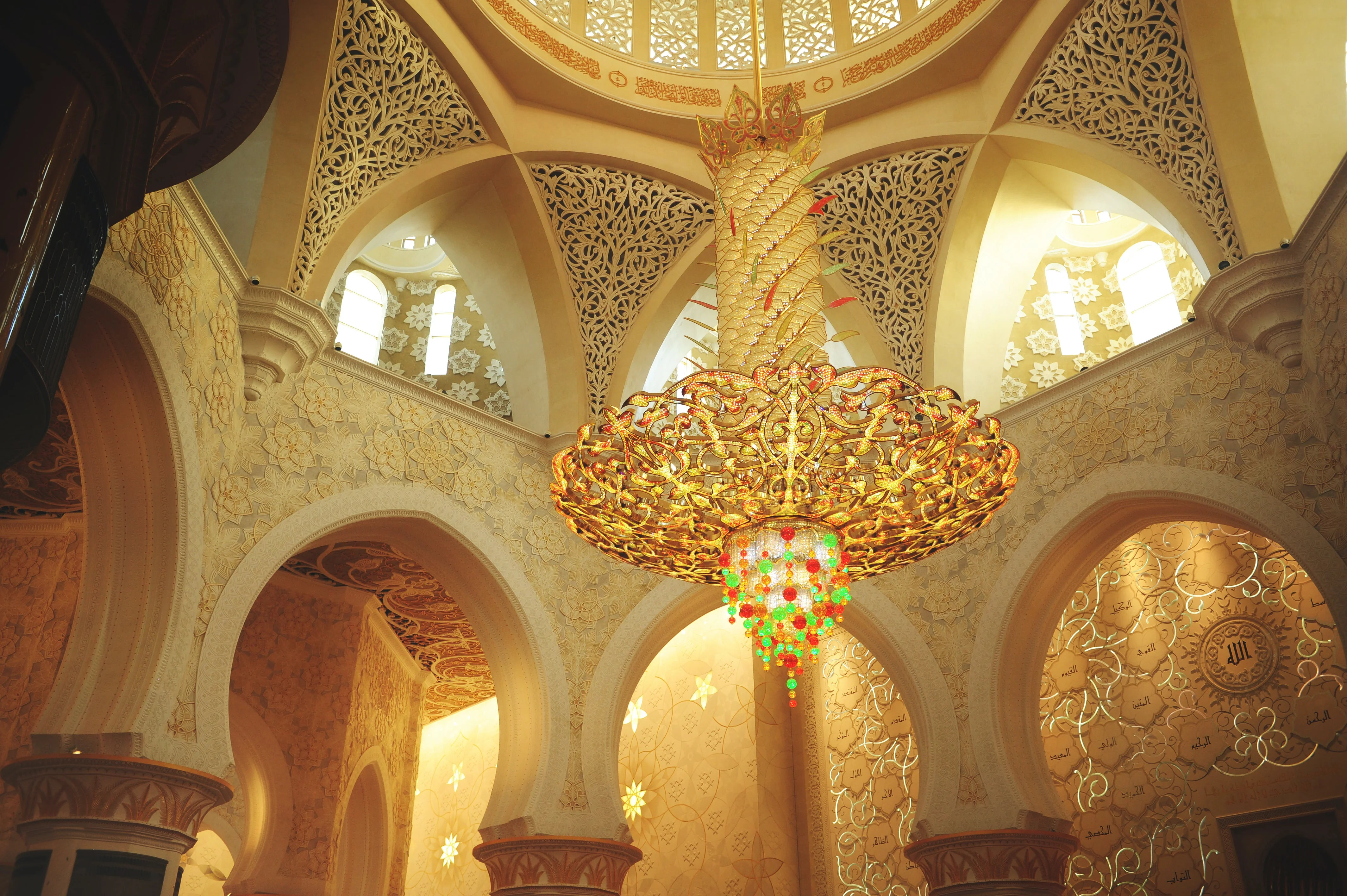 Golden chandelier and ornate arches inside Grand Mosque