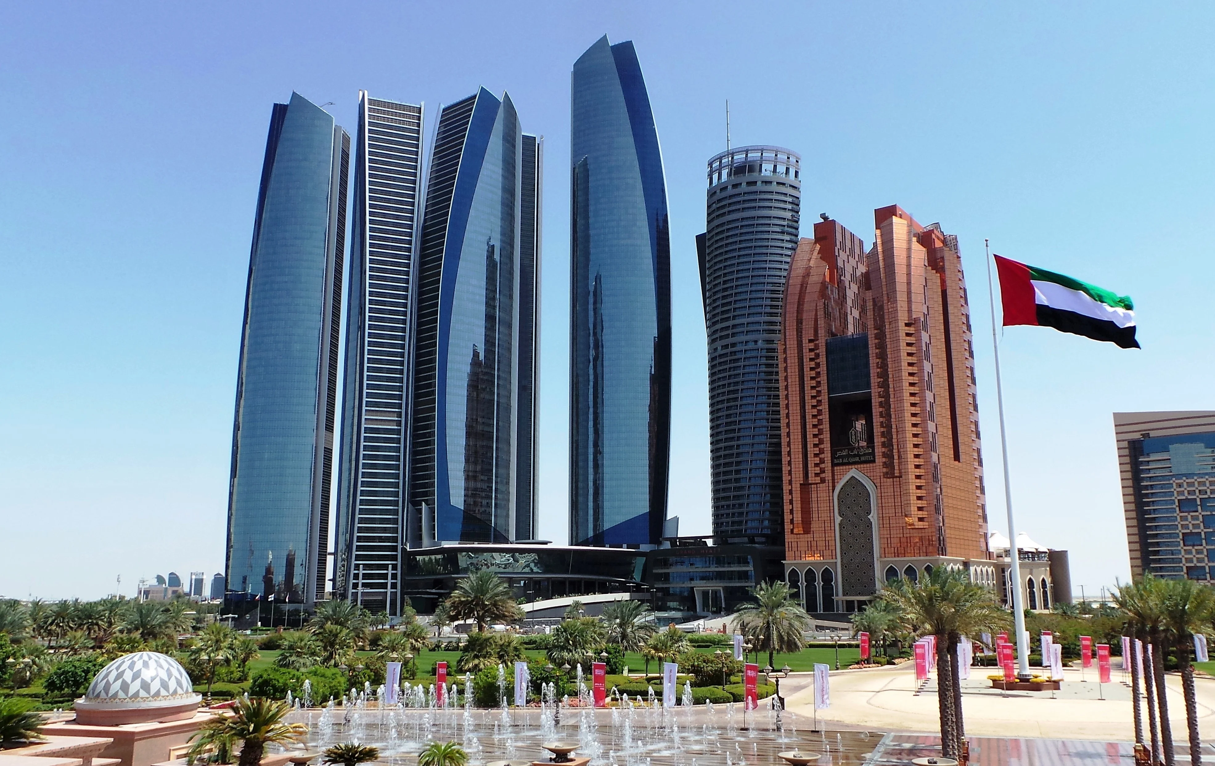 Etihad Towers and Emirates Palace with UAE flag in Abu Dhabi