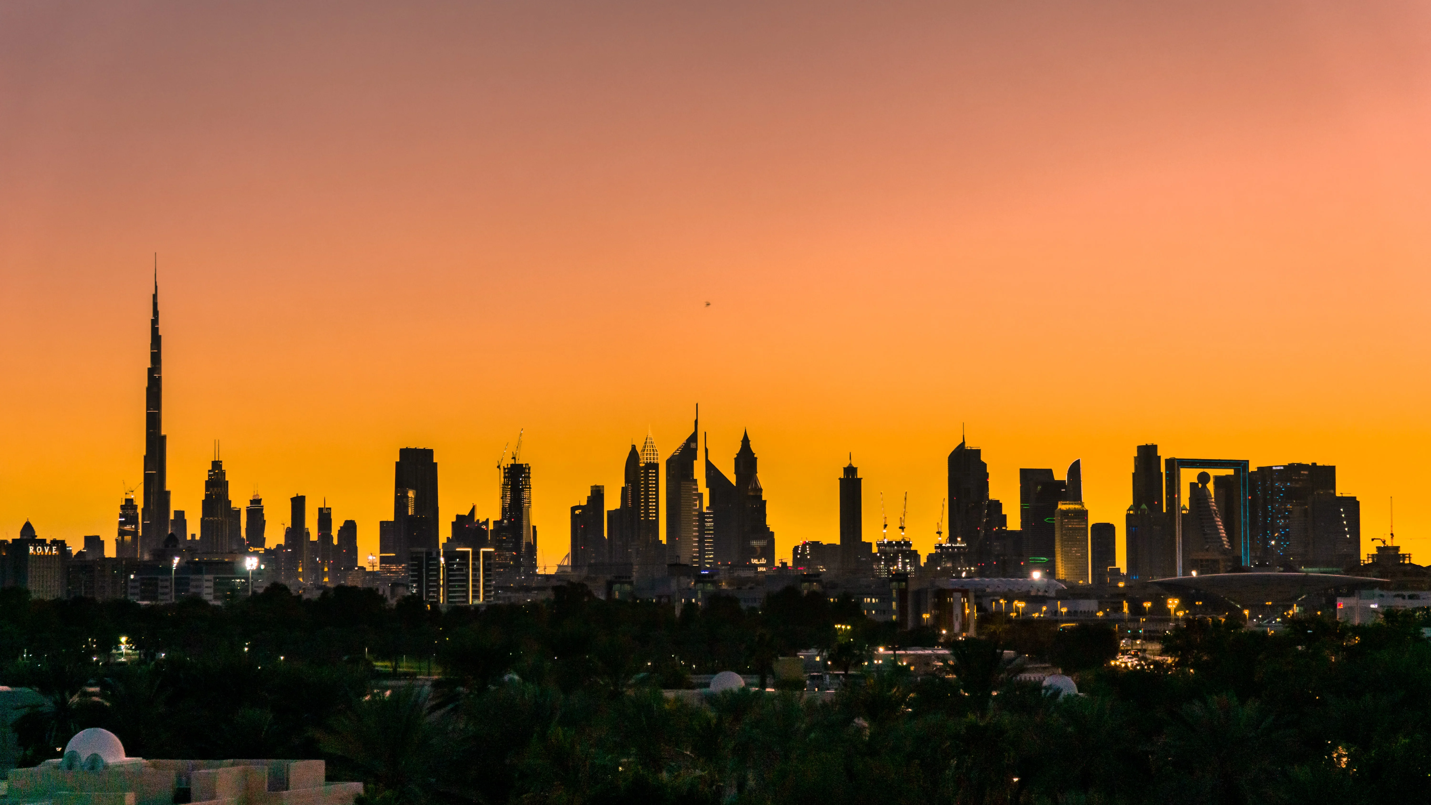 Dubai skyline in silhouette with vivid orange sunset