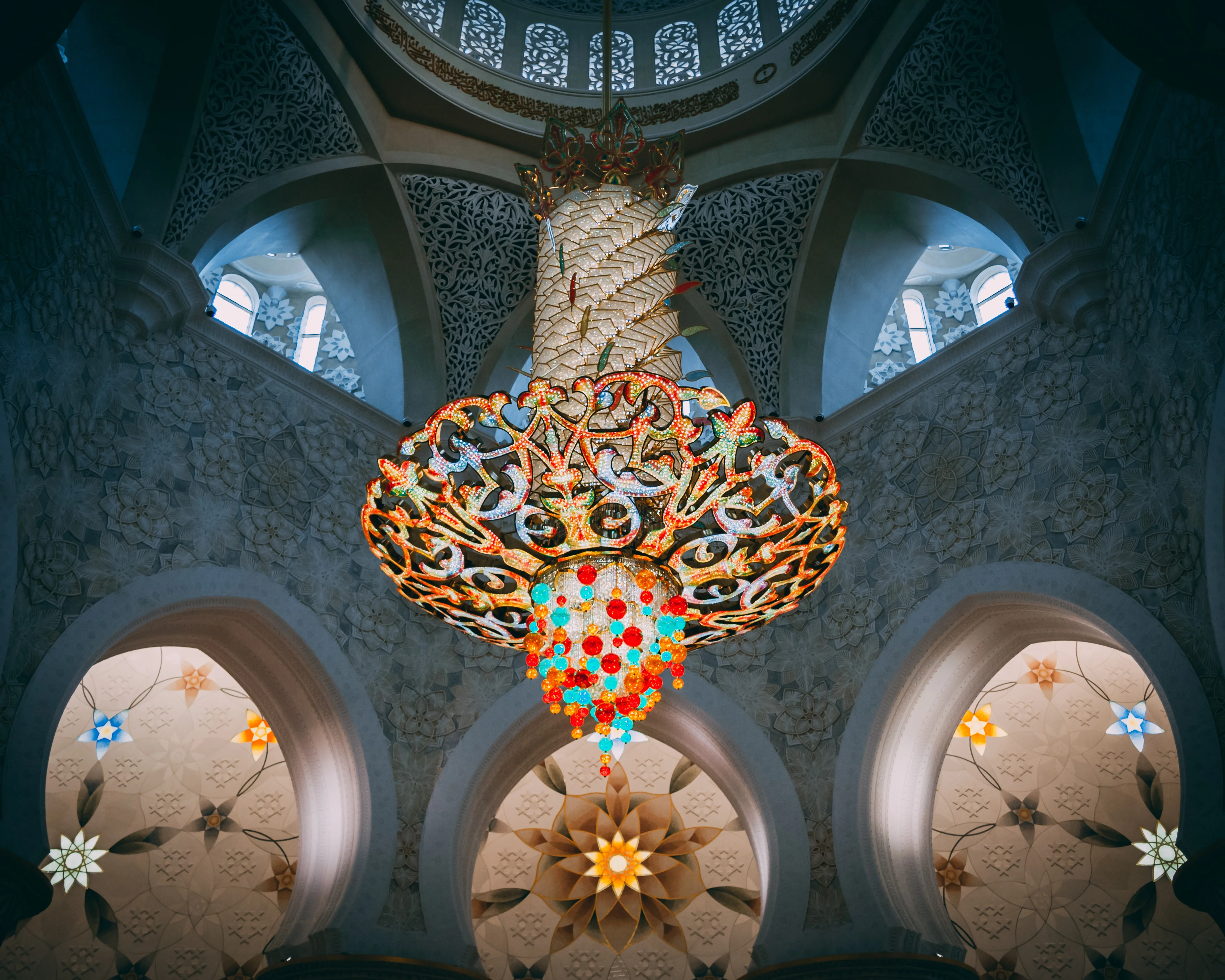 Colorful chandelier under patterned dome at Grand Mosque