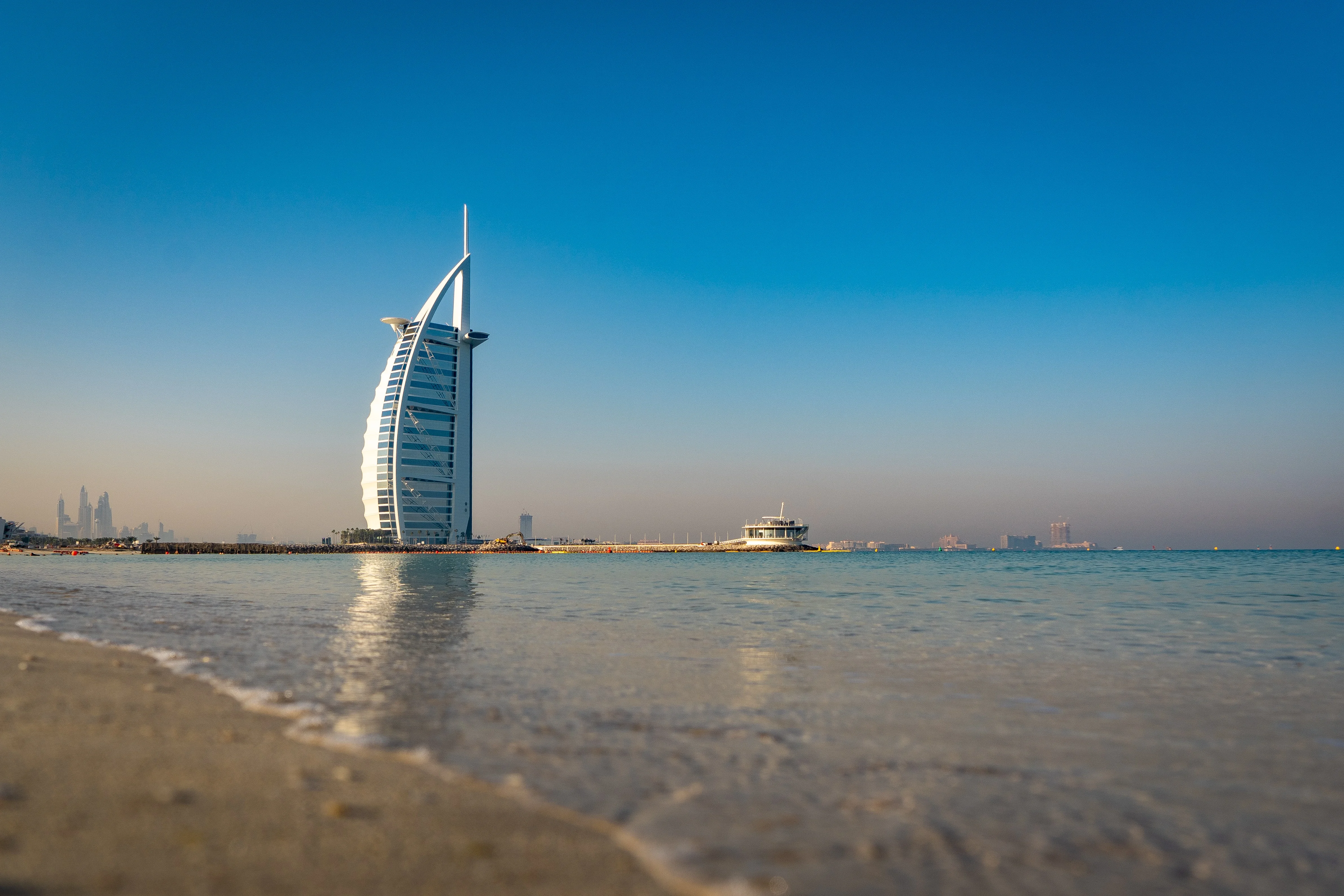 Iconic Burj Al Arab hotel standing by the sea at sunset