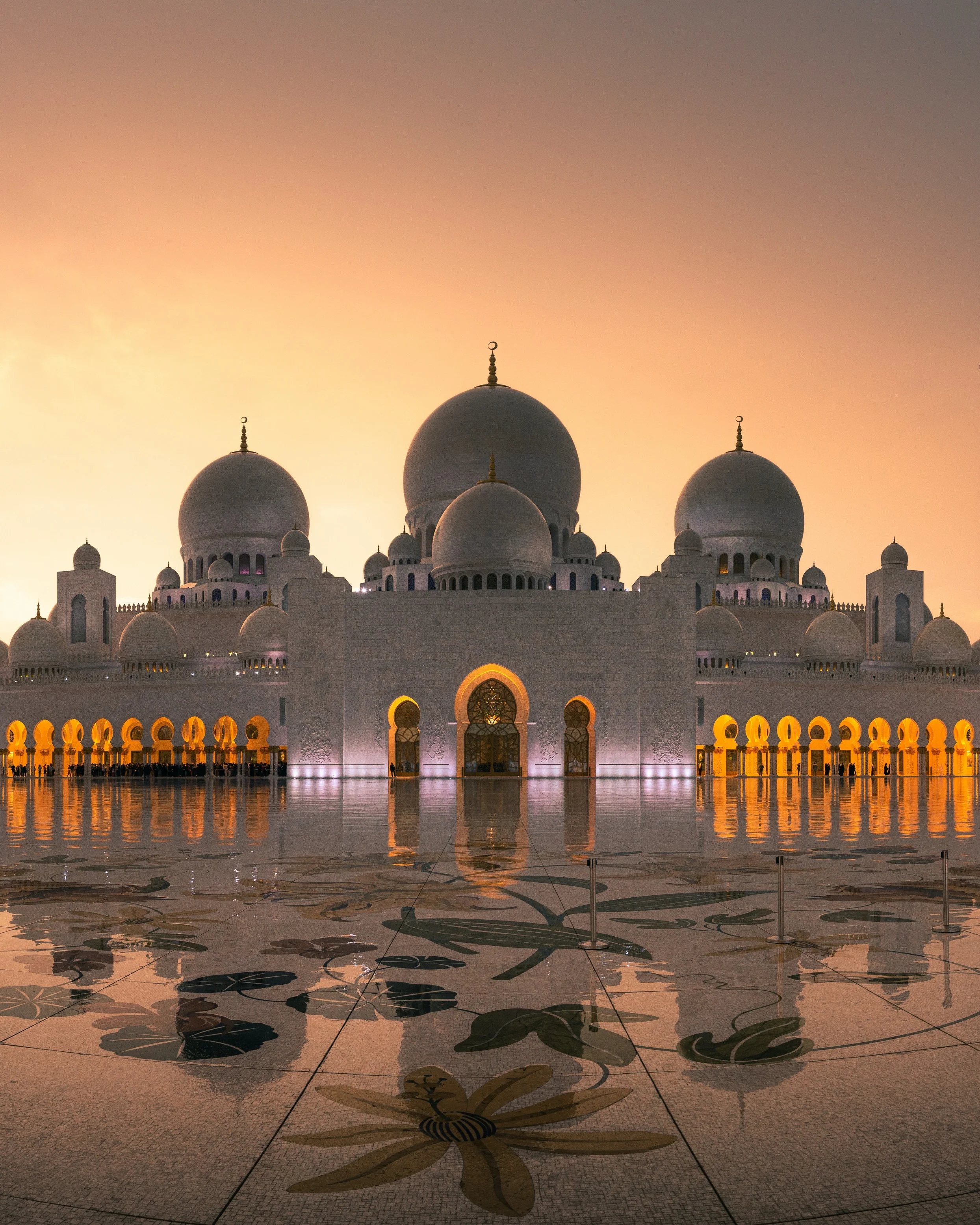 Sheikh Zayed Grand Mosque reflecting warm sunrise glow 