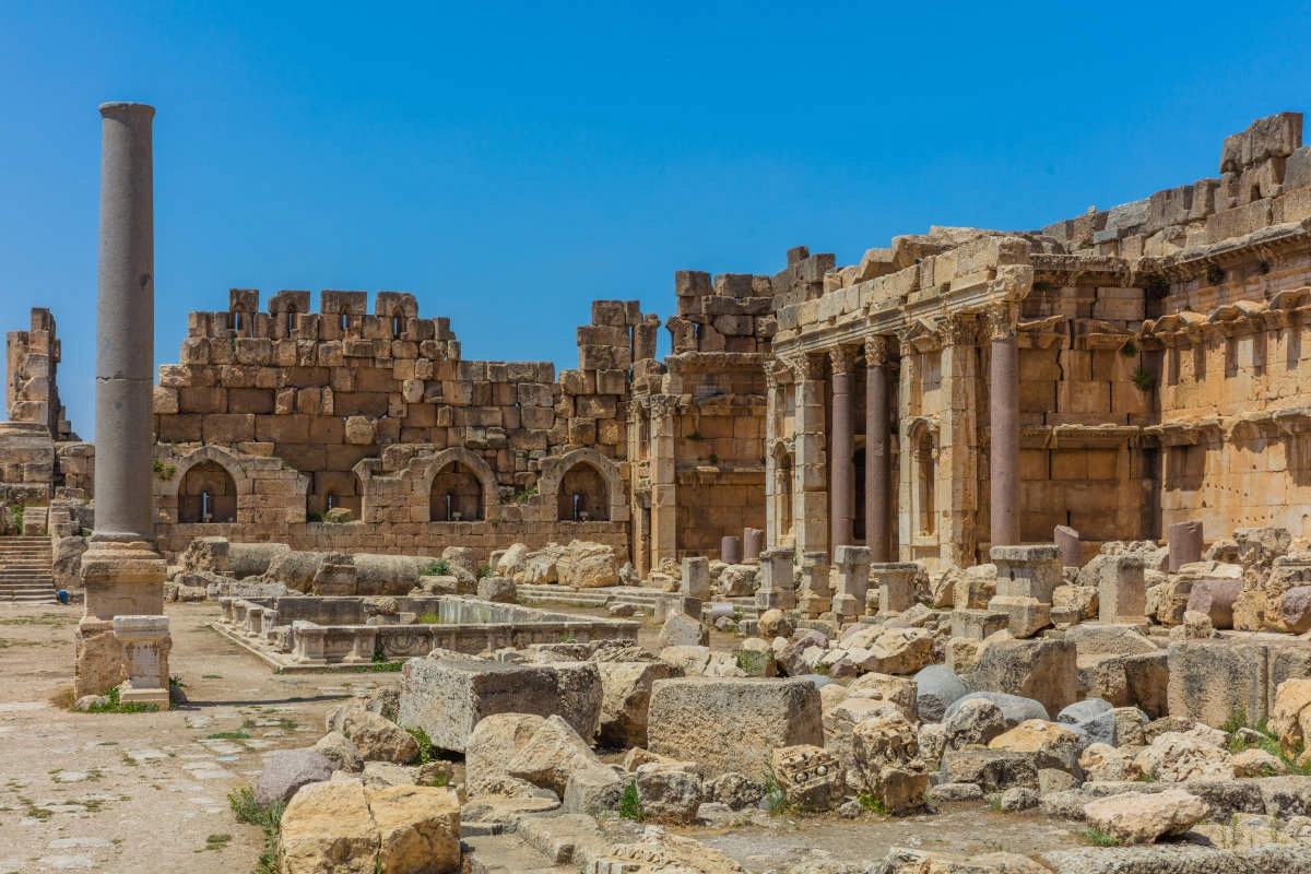 Ancient ruins of Baalbek with stone columns and Roman architecture under a clear blue sky.