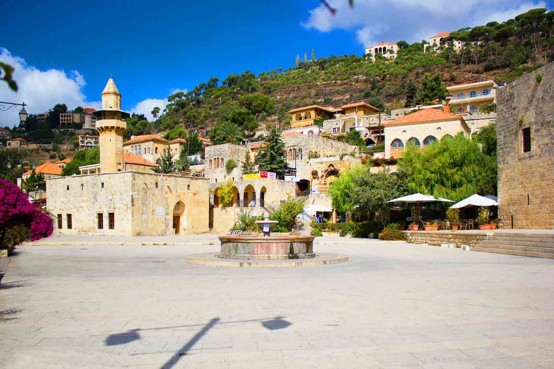 Traditional stone buildings and central fountain in Deir el Qamar village square.