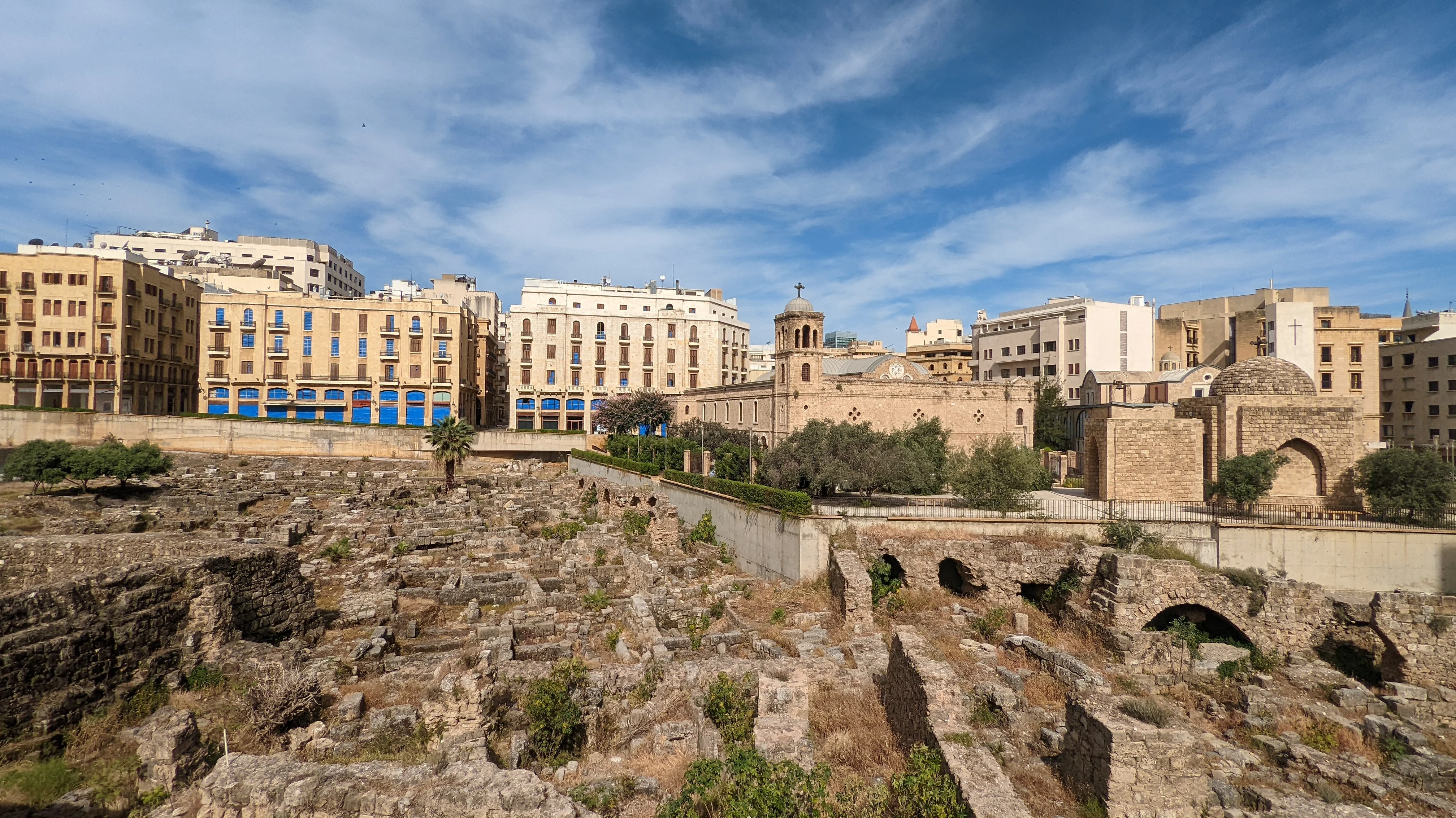 Roman ruins of Beirut with downtown buildings and historic churches in the background.