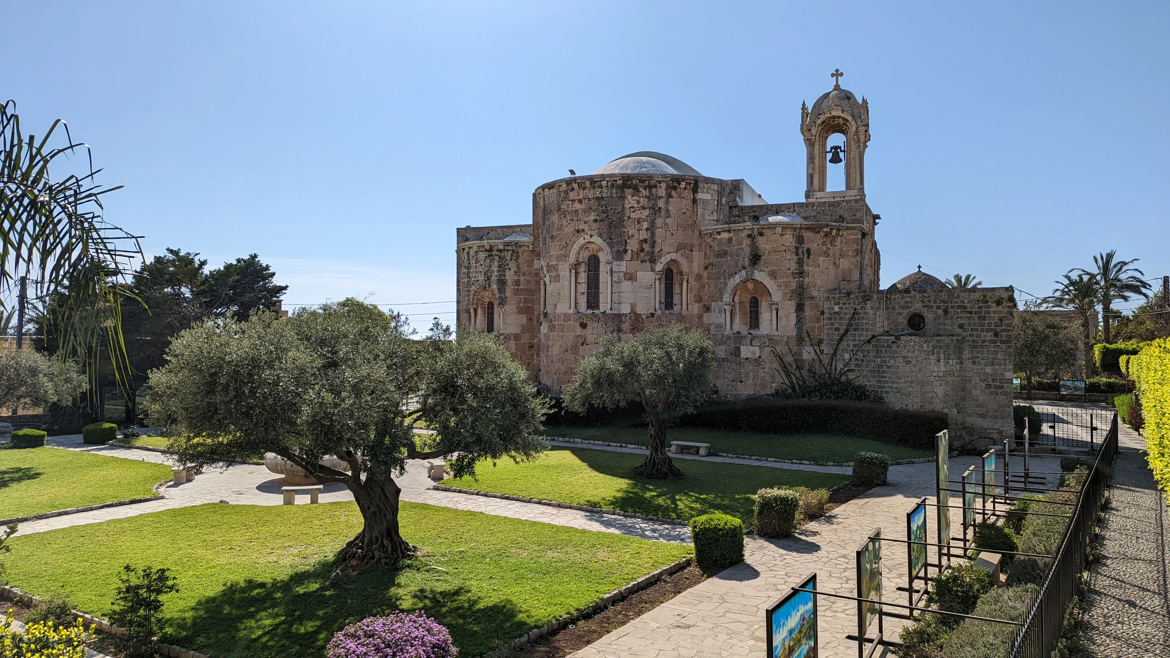 Saint John-Marc Cathedral in Byblos with manicured gardens and stone paths.