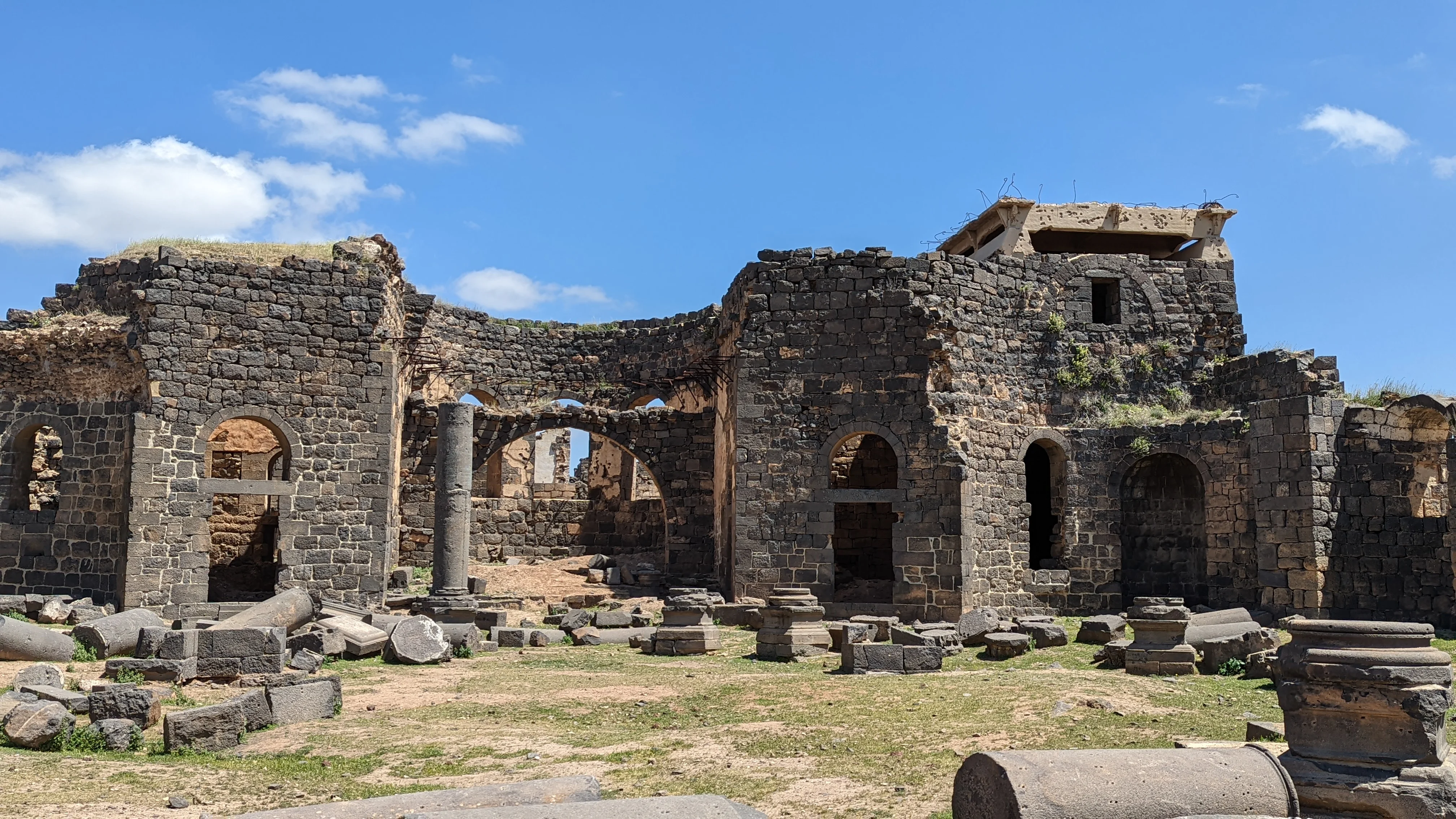 Ancient black basalt ruins and columns in a deserted archaeological site in southern Syria