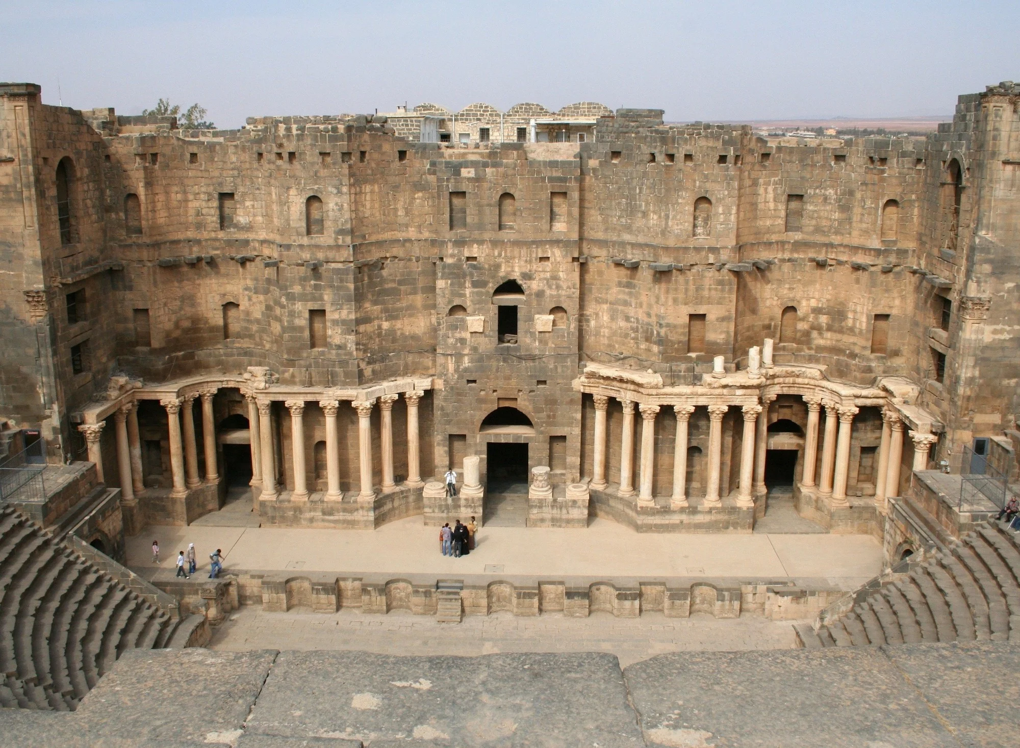 Central stage of Bosra Roman theater with grand arched entrance and colonnaded backdrop