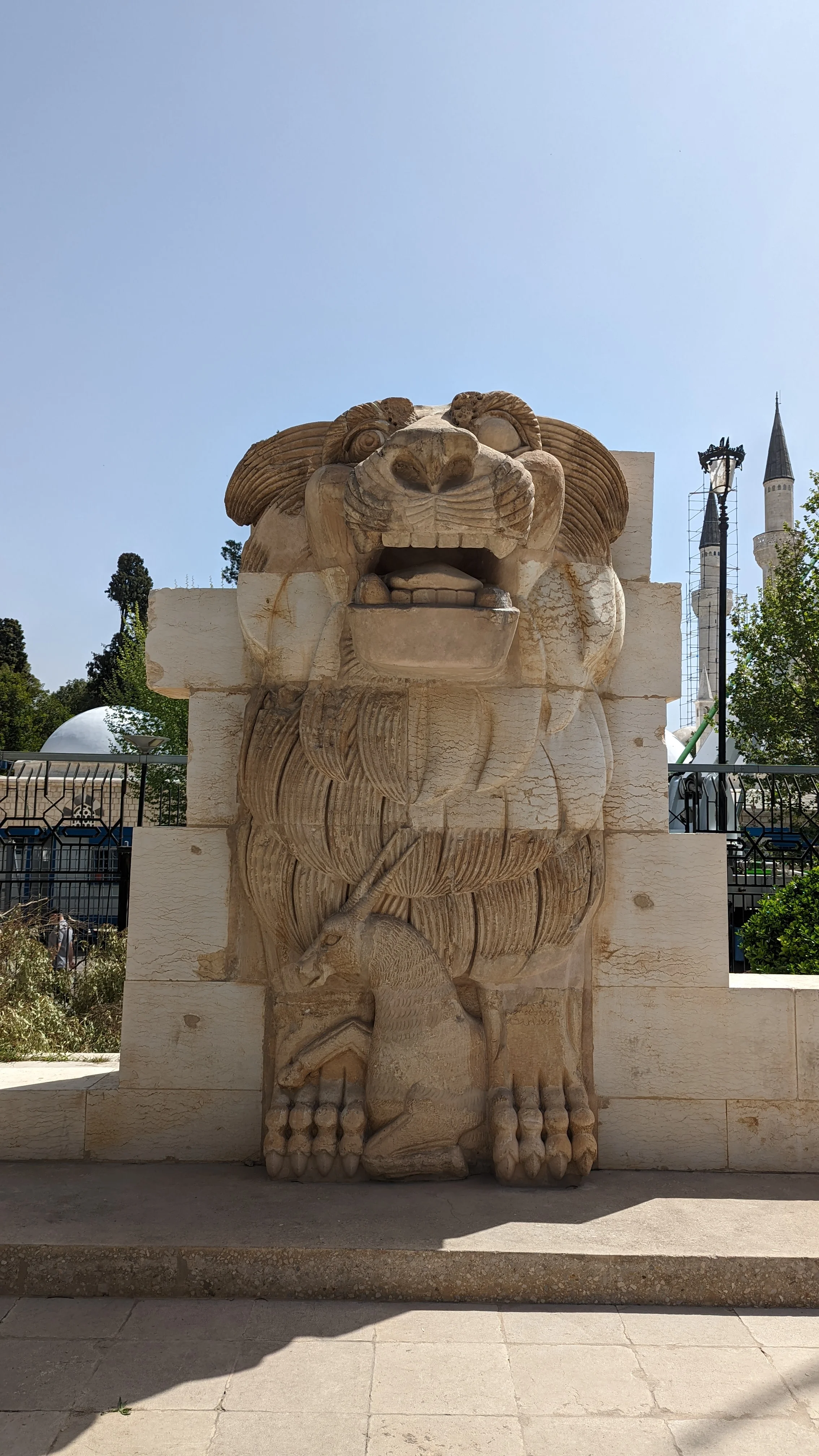 Lion of al-Lat statue in Damascus, an ancient artifact with intricate carvings of a lion and antelope