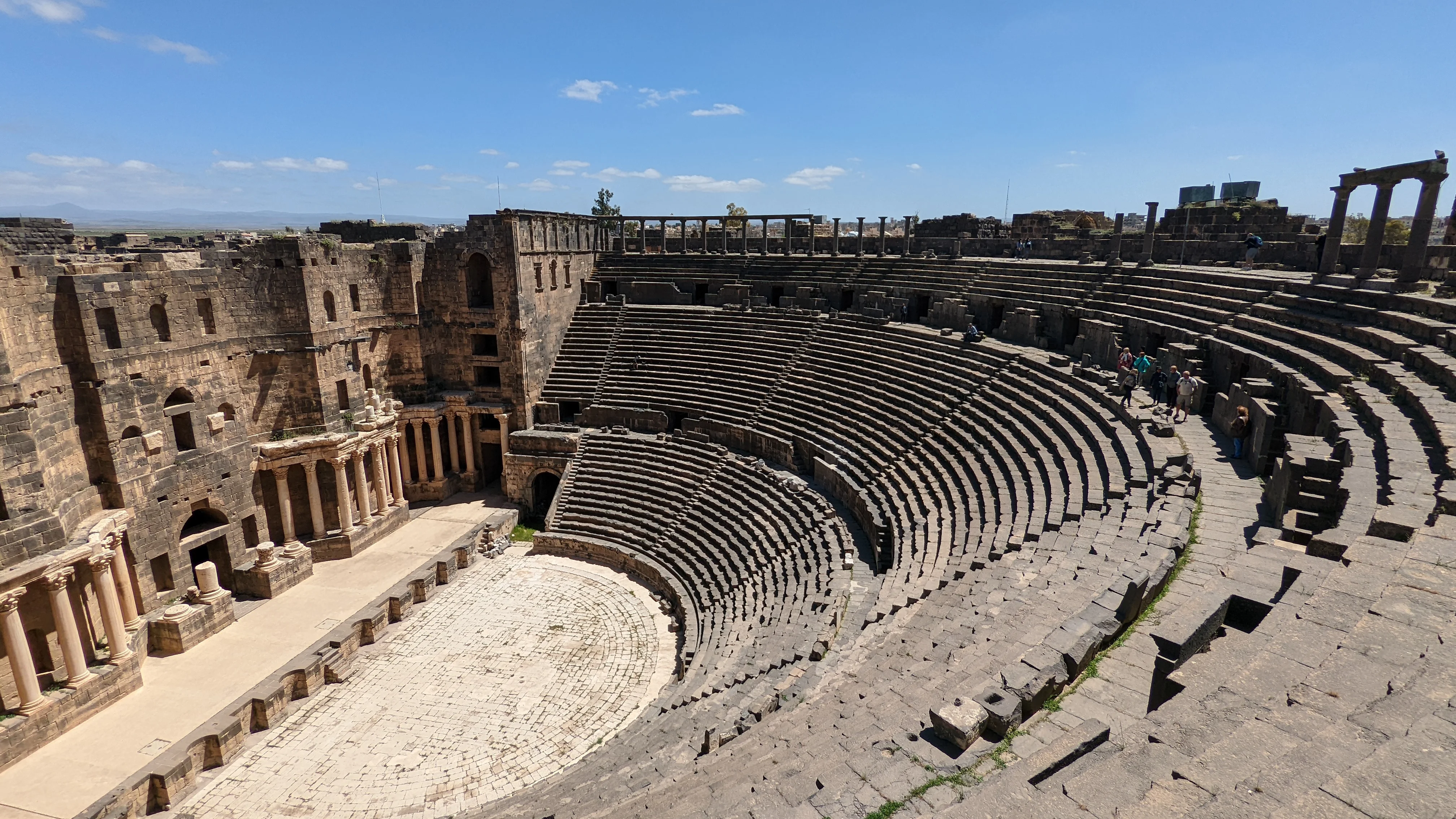 Ancient Roman amphitheater in Bosra, Syria with preserved stone seating and stage columns