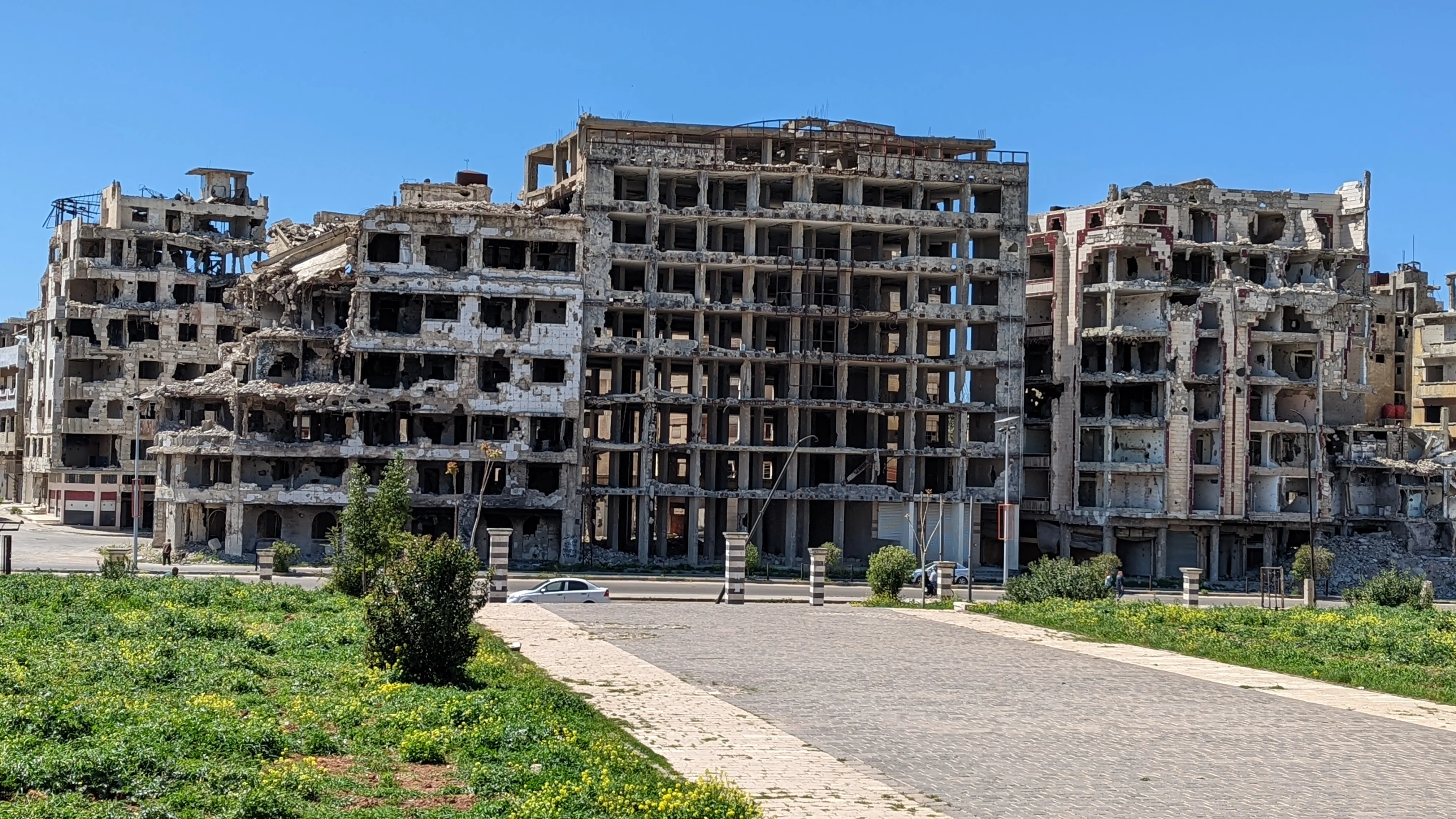 War-damaged buildings in Homs with bullet-riddled concrete frames and exposed interiors