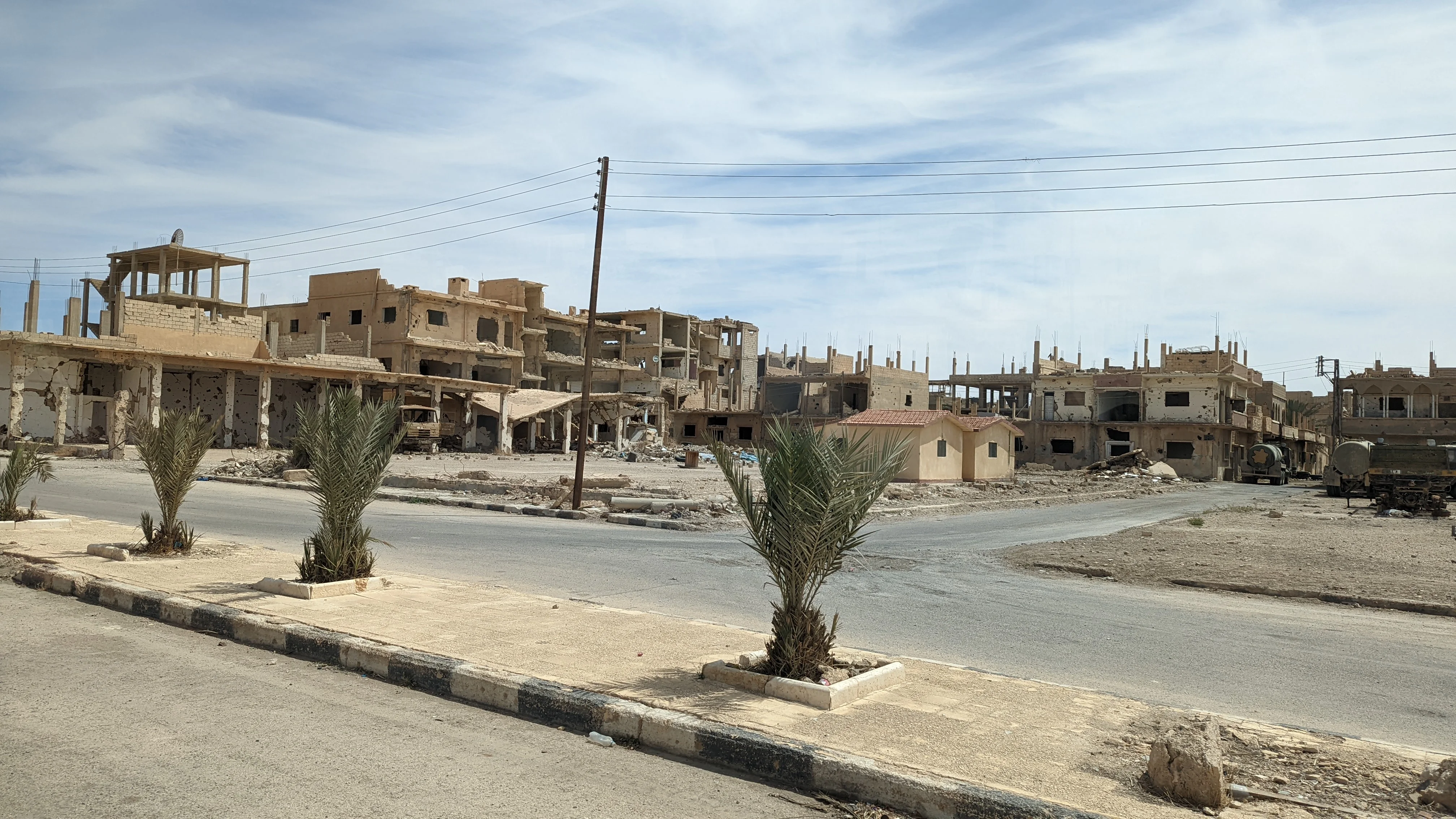War-damaged buildings in Palmyra with bullet holes and shell damage visible on facades