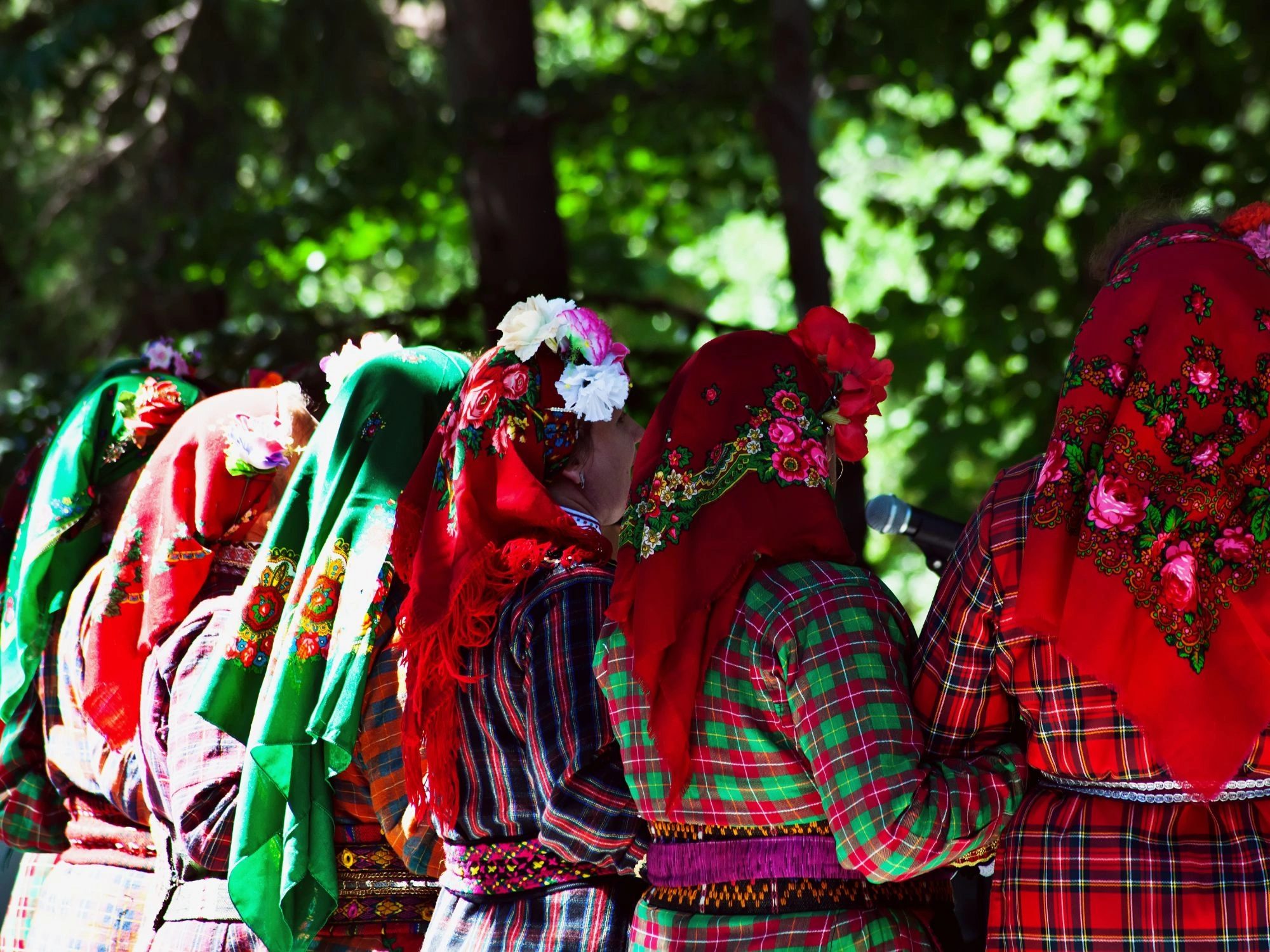 Women in traditional Bulgarian folk costumes with colorful embroidered headscarves at festival