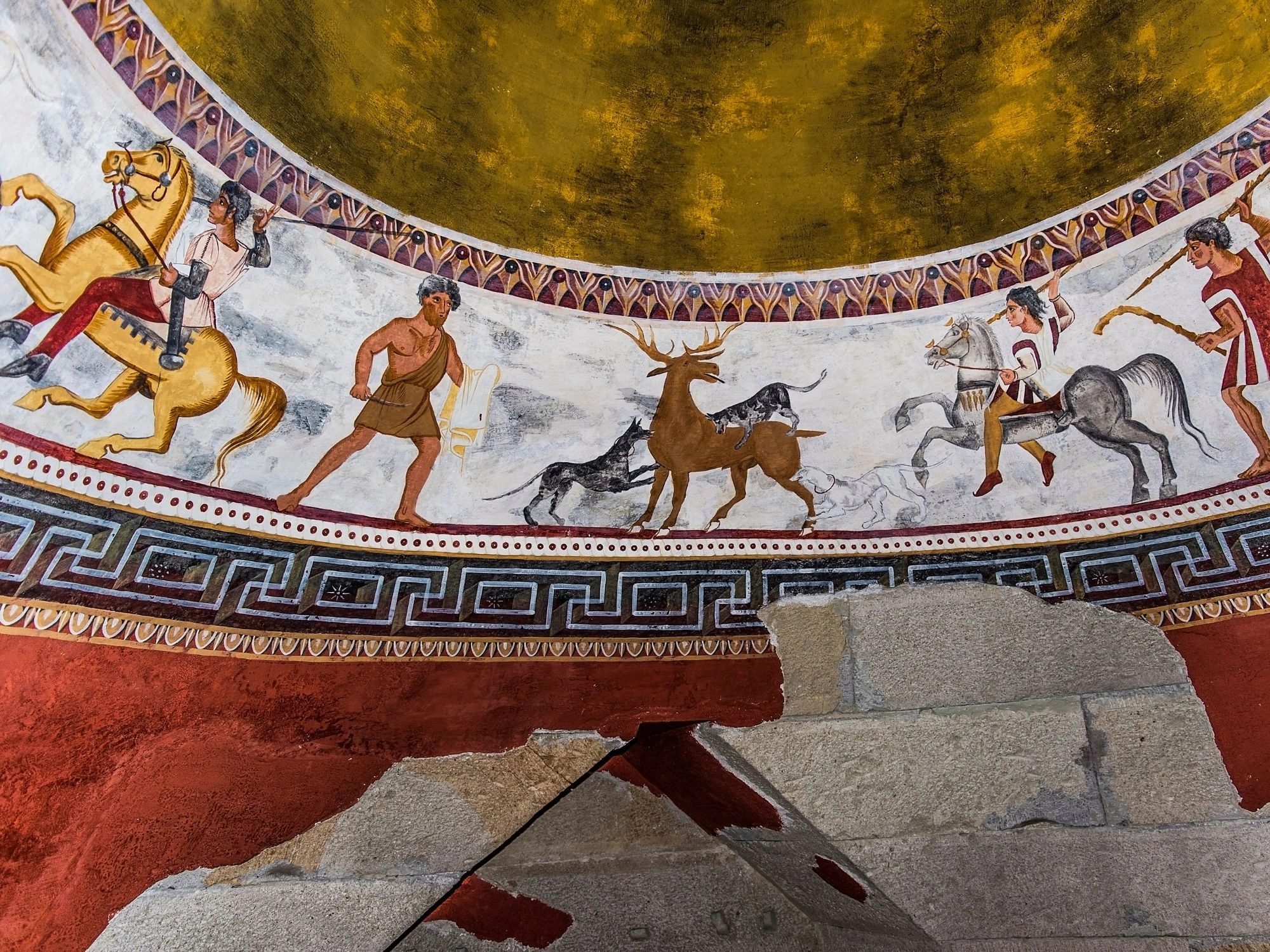 Colorful ancient mural of horsemen and deer inside a Thracian tomb chamber.