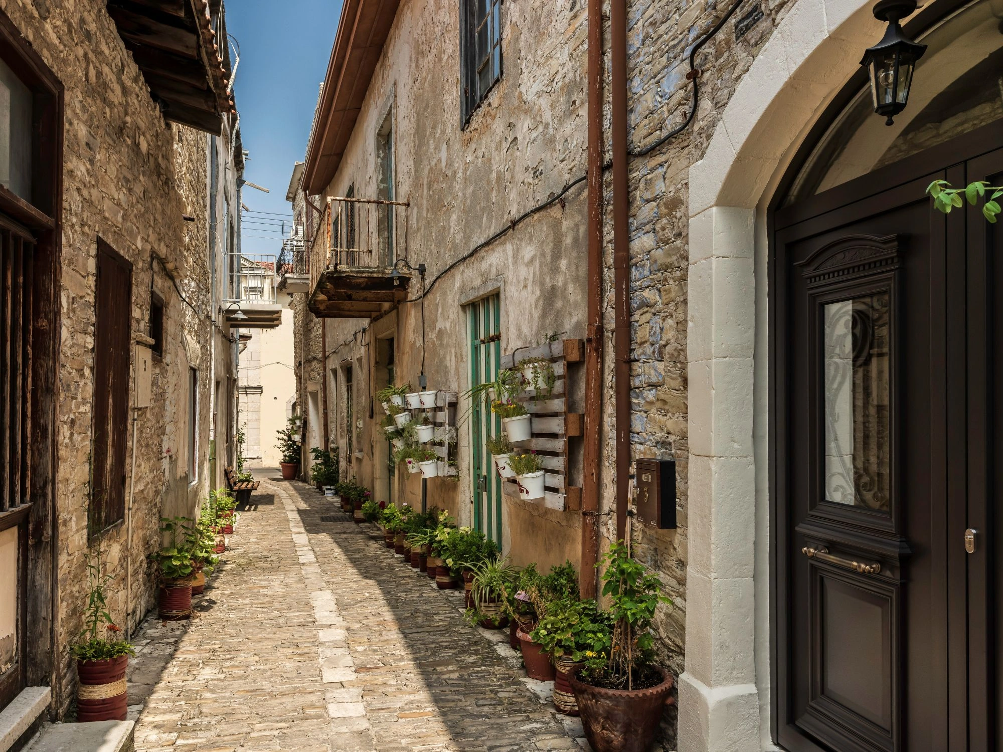 Narrow stone alley with flower pots in the village of Lefkara, Cyprus.