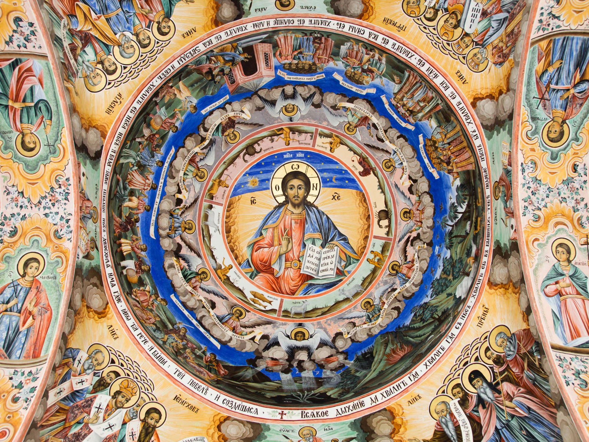 Vibrant frescoes on the ceiling of Rila Monastery, depicting religious figures and biblical scenes in rich colors.