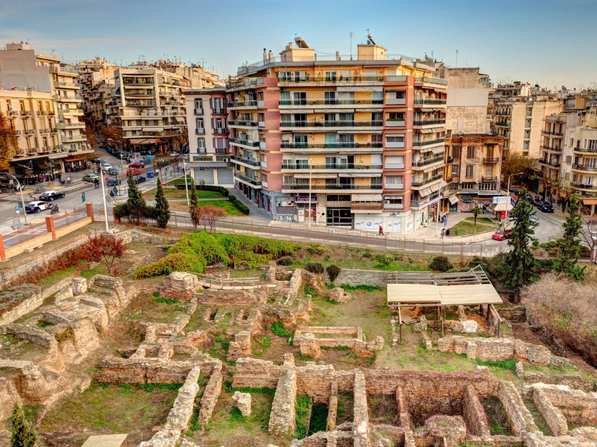Ancient ruins in Thessaloniki surrounded by apartment buildings and city streets.