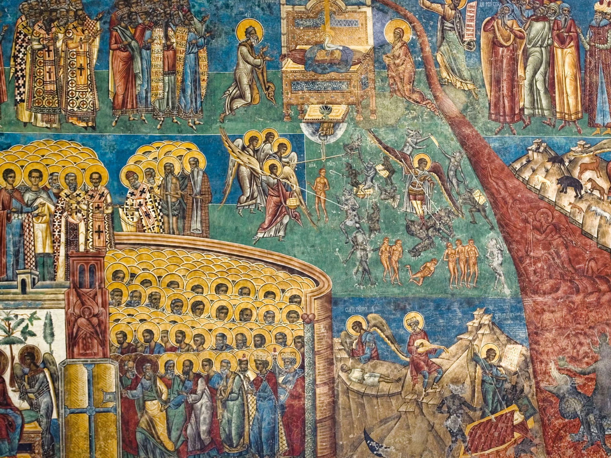 Detailed fresco at Voronet Monastery depicting religious scenes with saints, angels, and demons.