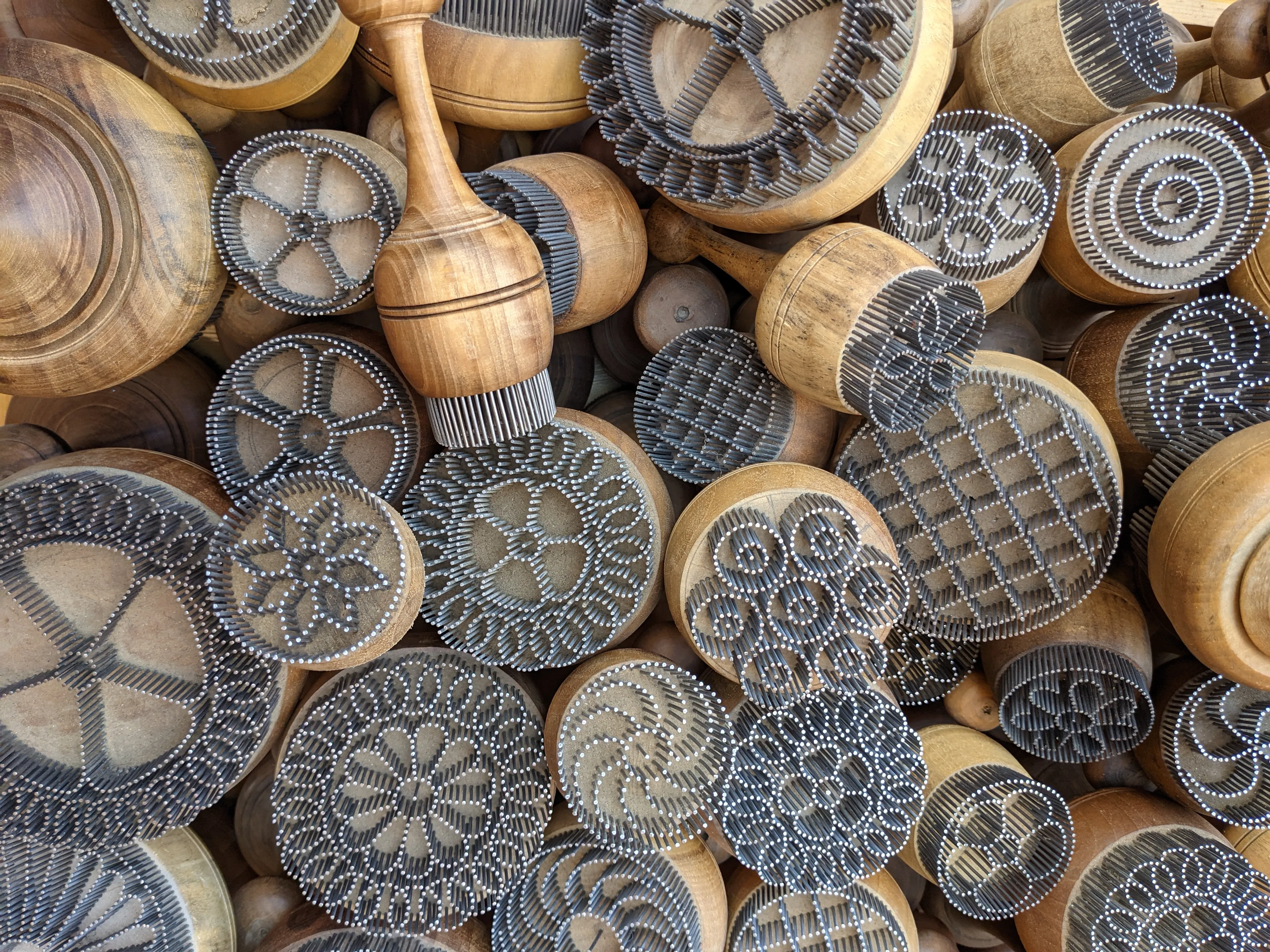 Intricate Uzbek bread stamps displayed at a market in Uzbekistan.