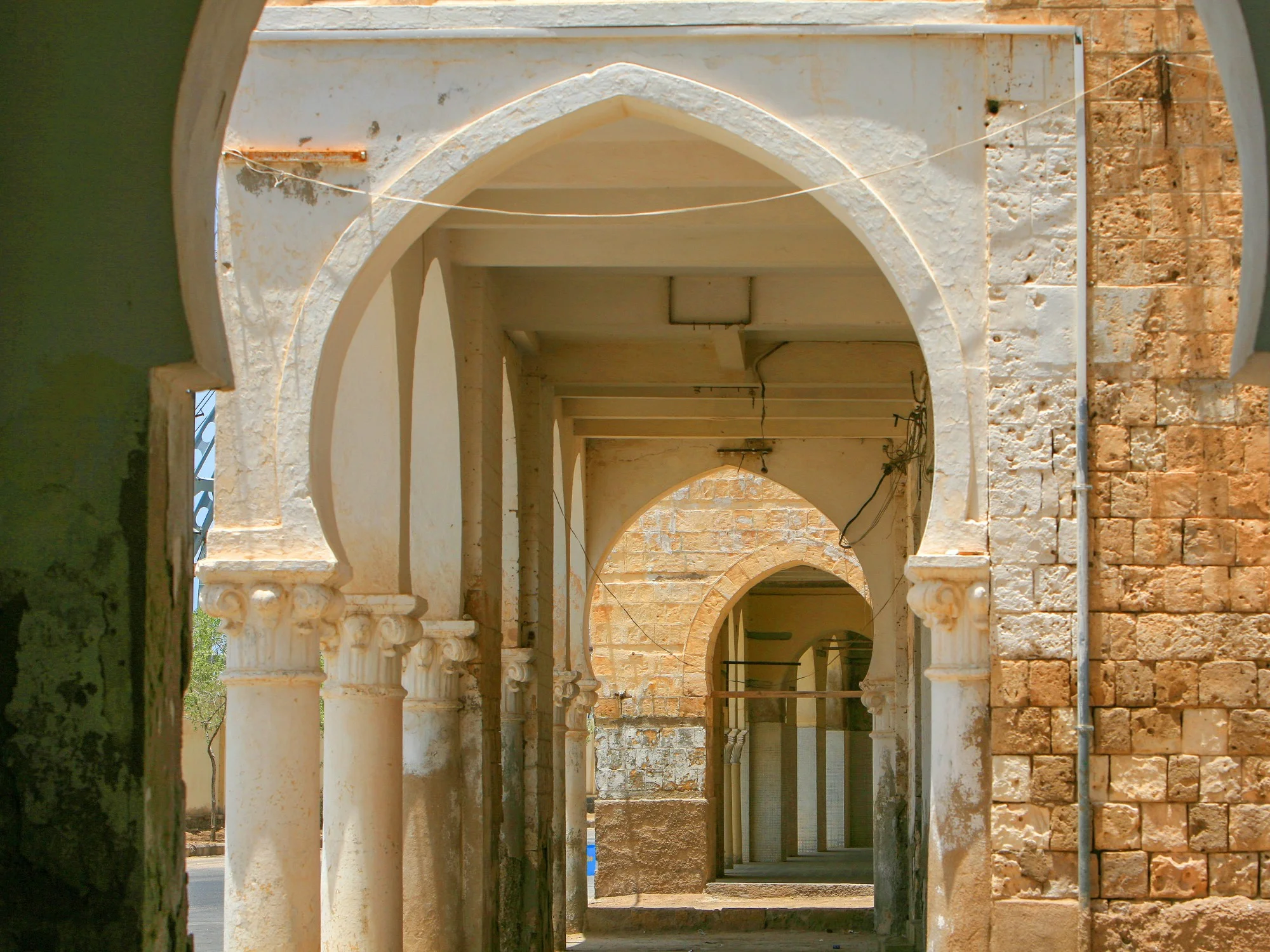 Historic colonial-era arched colonnade with weathered pillars in Asmara, Eritrea