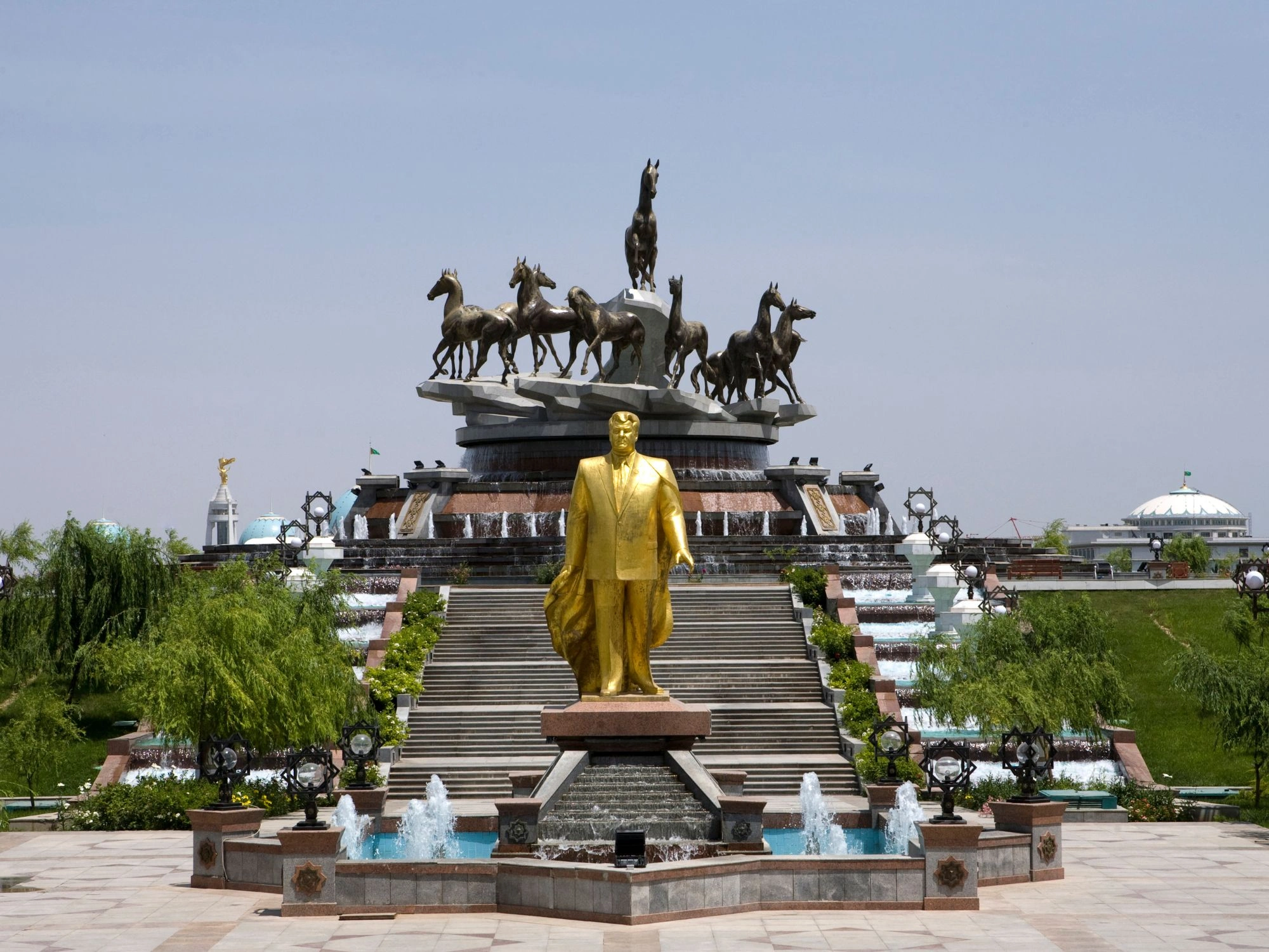 10 Years of Independence Monument in Ashgabat, Turkmenistan, with golden statue and fountains.