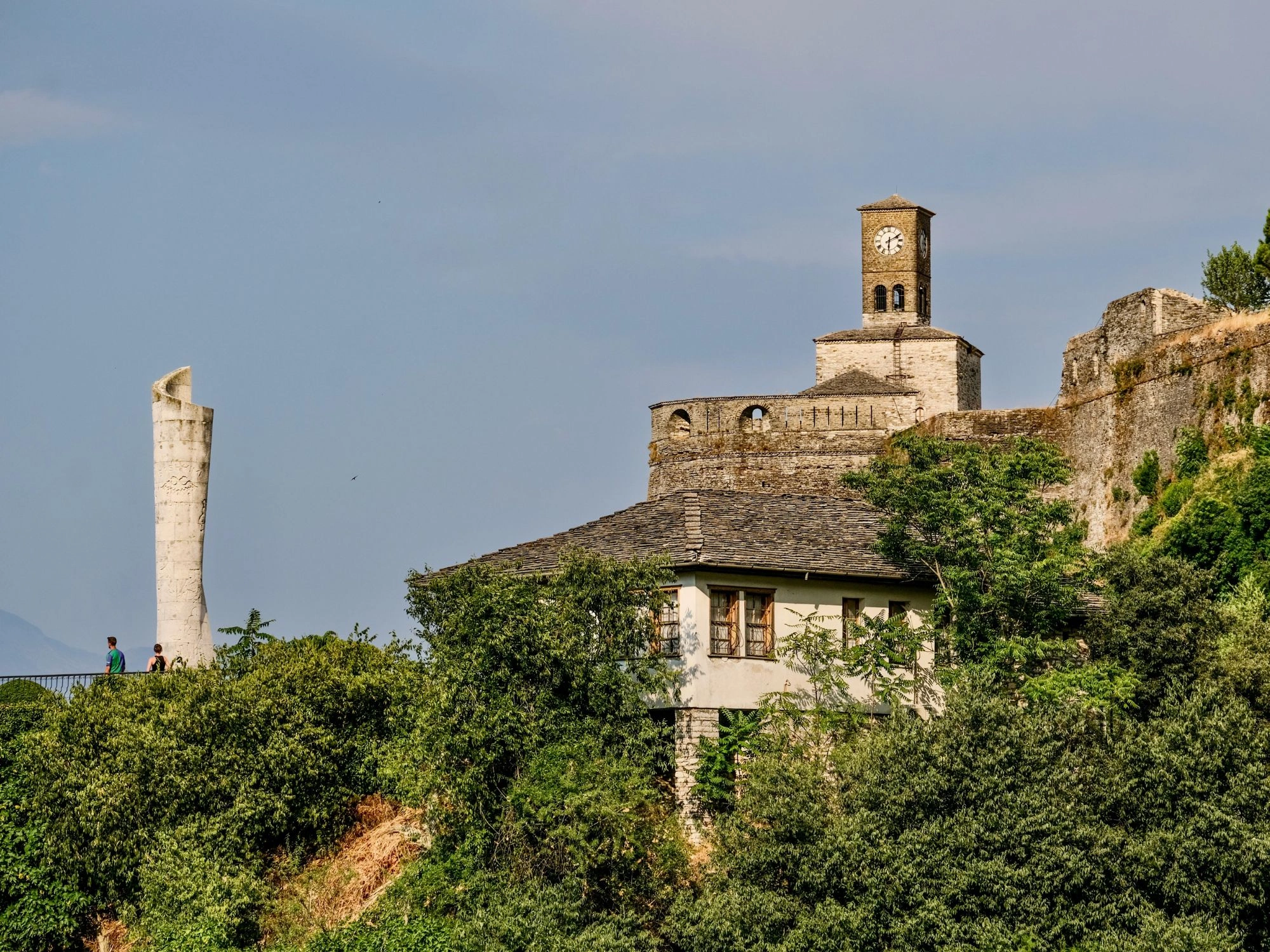 Historic Gjirokastër Castle standing above the town, with views of stone houses and lush green surroundings in Albania.