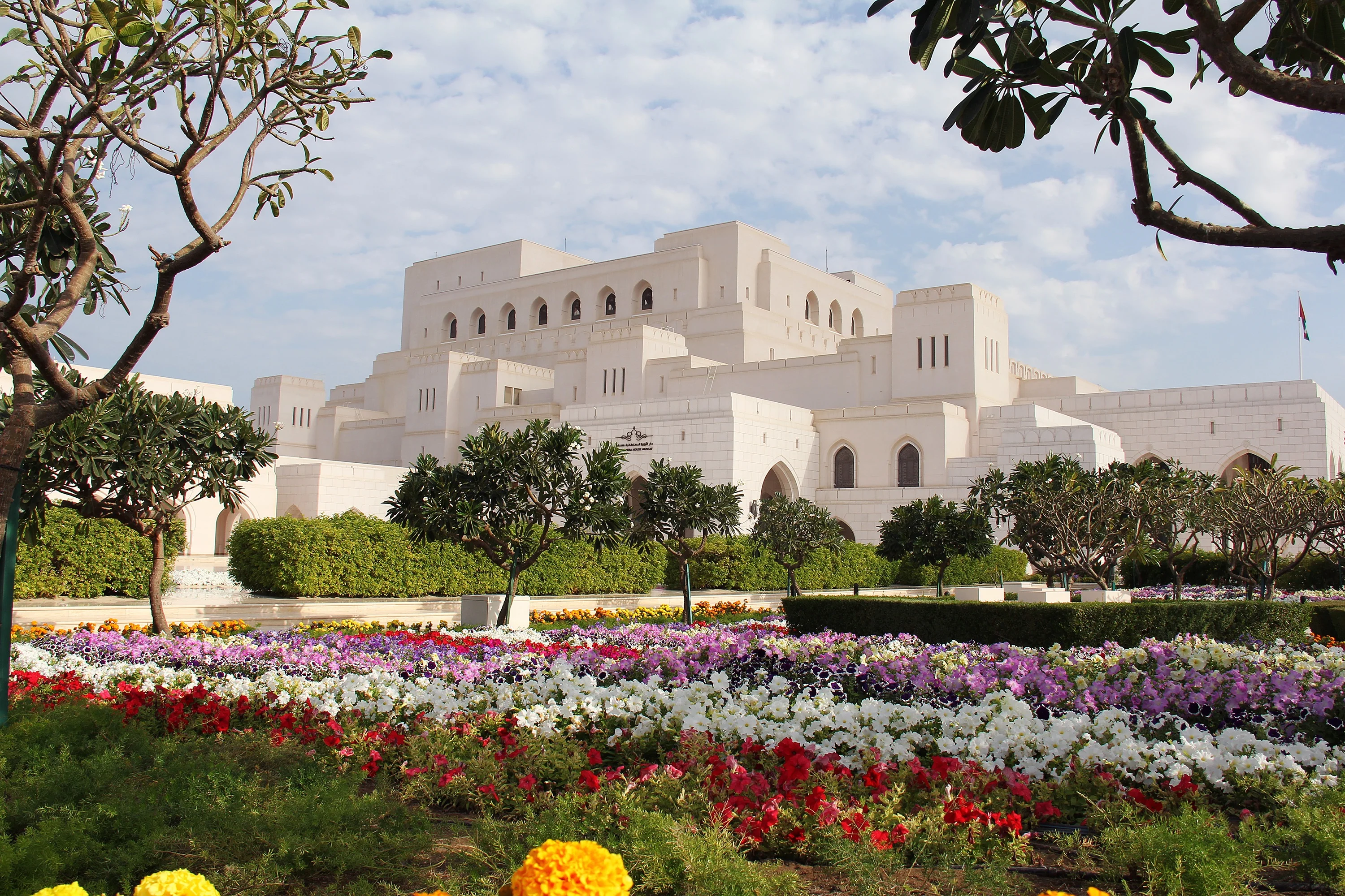Garden view of Royal Opera House Muscat surrounded by flowers on an Oman tour.