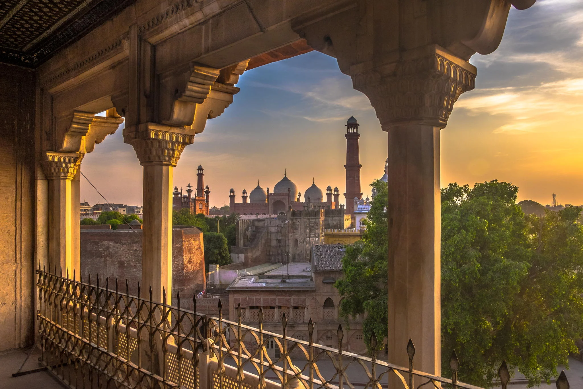 Badshahi Mosque sunset view from Lahore Fort, Mughal architecture at golden hour.