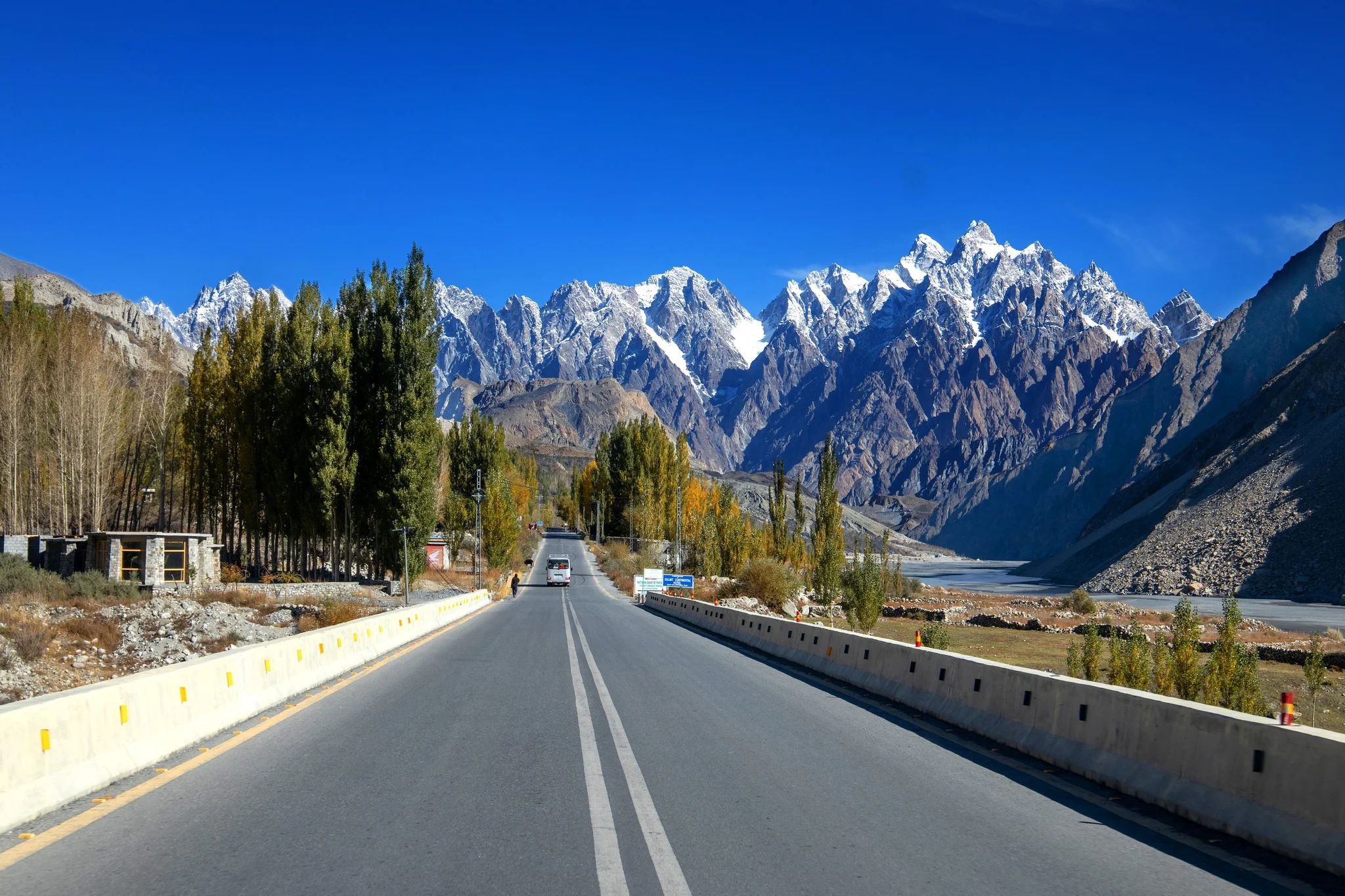 Karakoram’s Passu Cones rise dramatically behind golden trees and rivers in upper Hunza Valley.