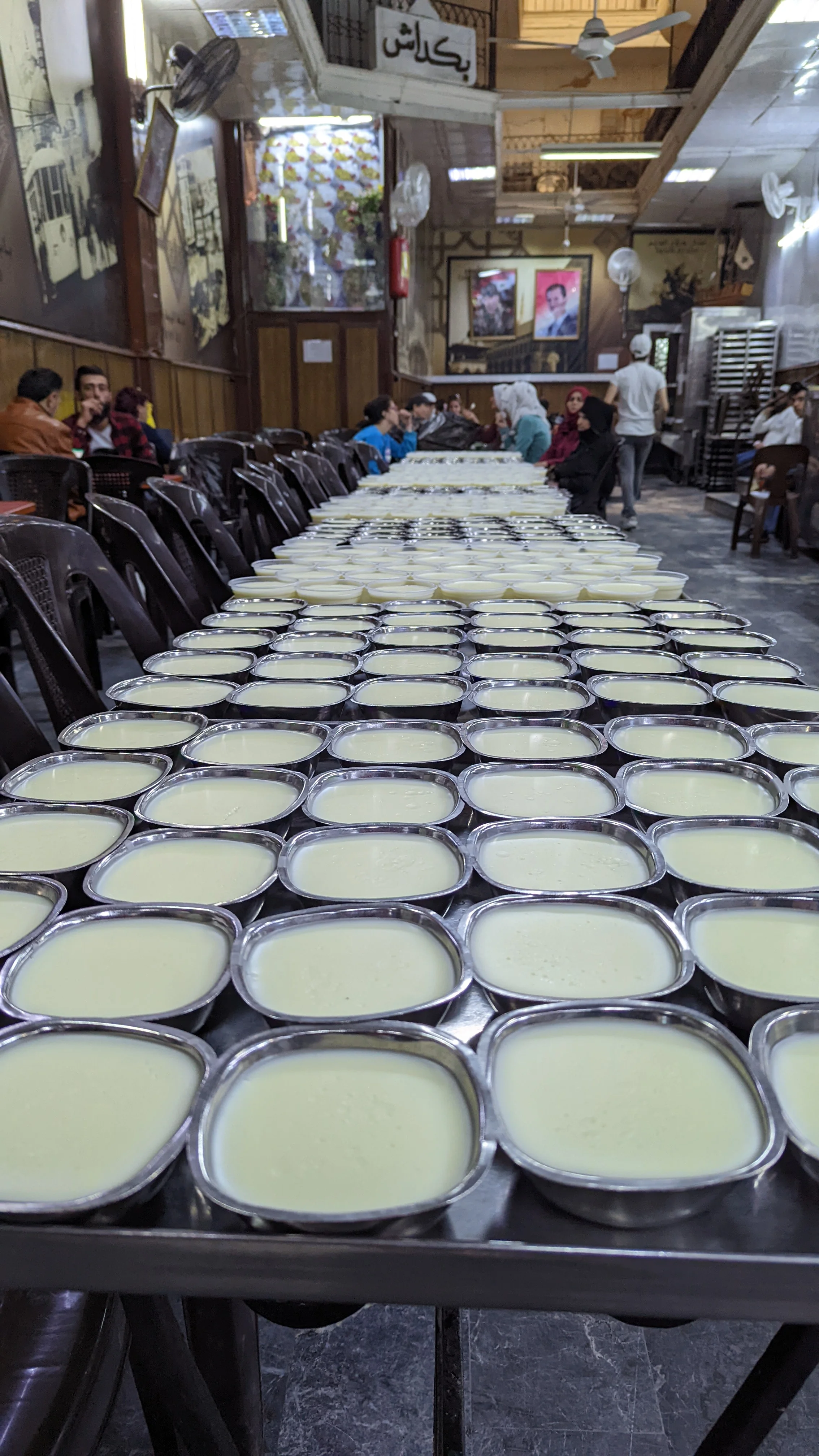Rows of traditional Middle Eastern milk pudding served fresh at a Damascus dessert shop