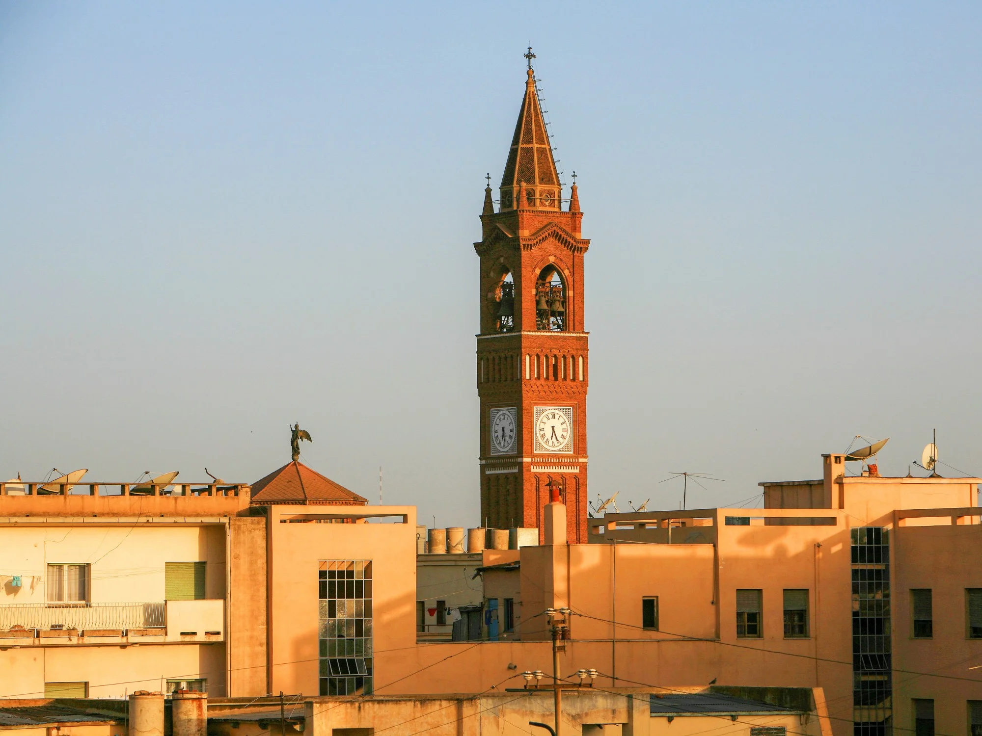 Asmara's Catholic Cathedral clock tower in Eritrea, red brick Italian-style architecture rising above city rooftops