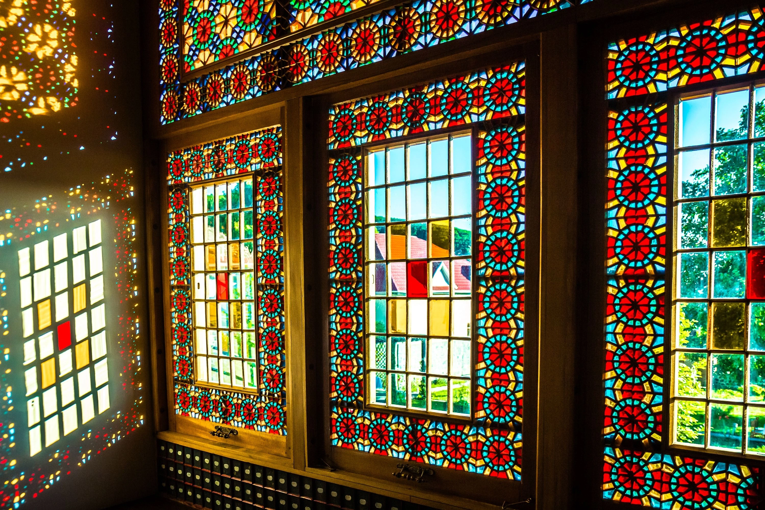 Colorful stained glass shebeke windows of Sheki Khan’s Palace in Azerbaijan with sunlight reflections