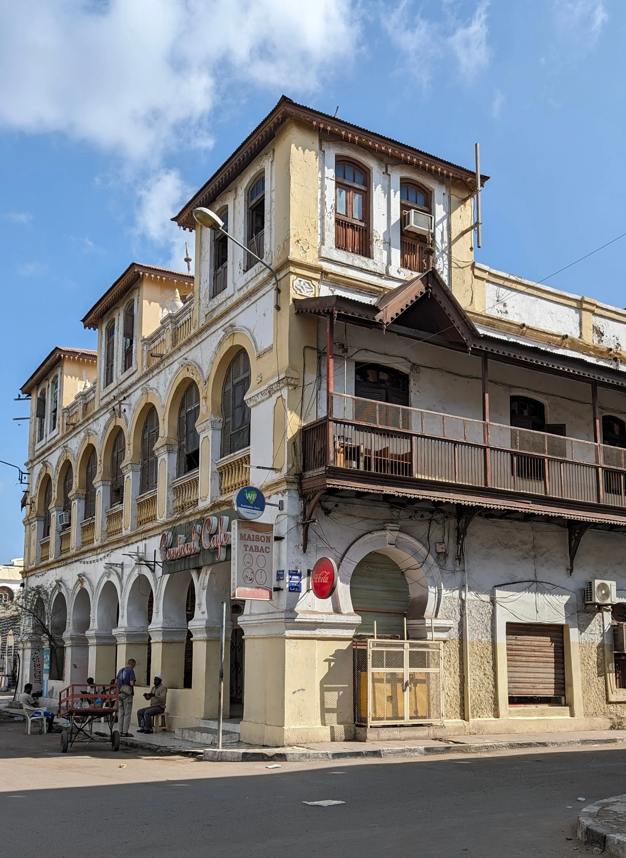 Colonial-style yellow and white building in Djibouti City under a blue sky.