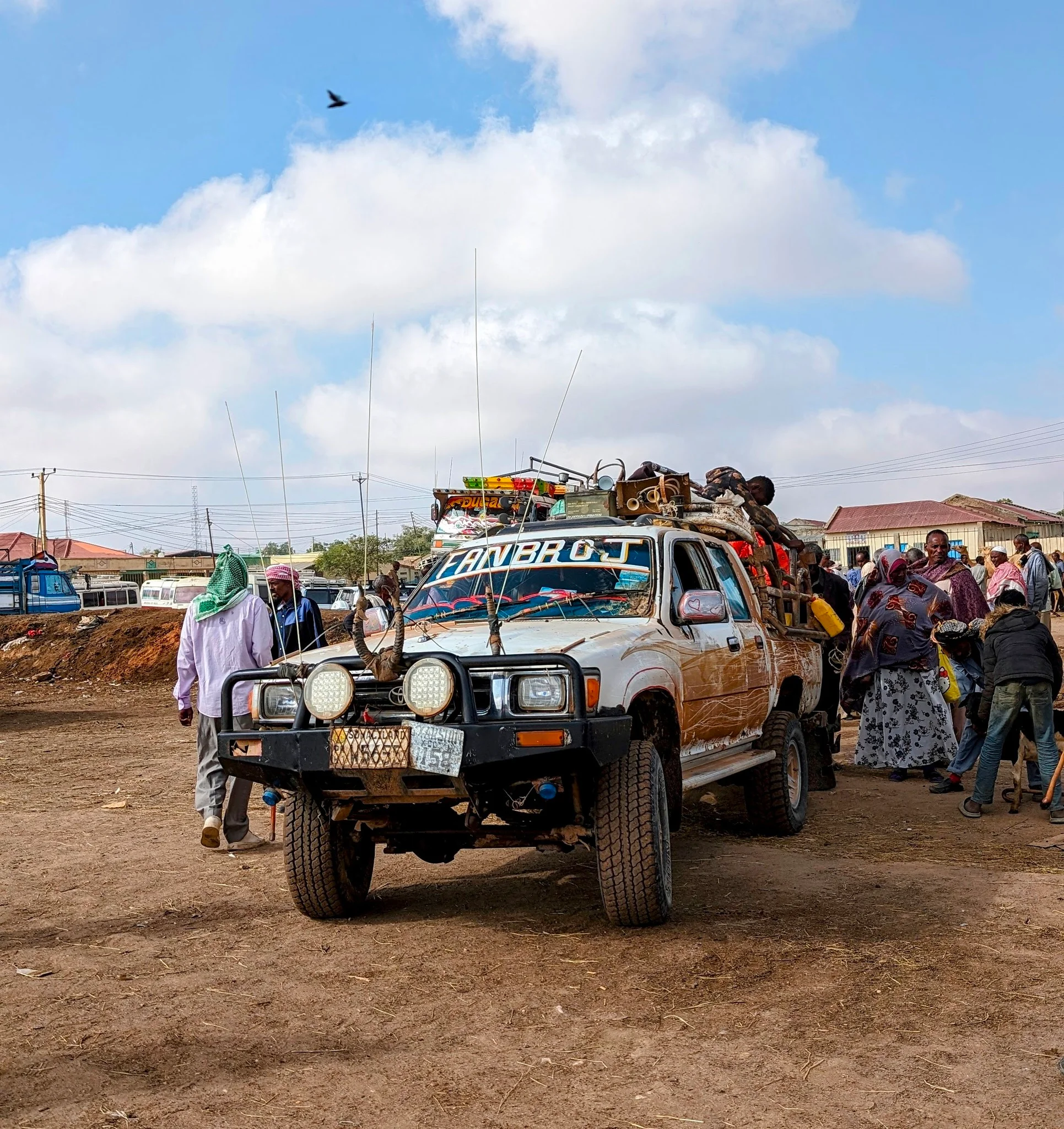 Heavily laden 4x4 truck packed with goods and passengers in a bustling Somaliland town.