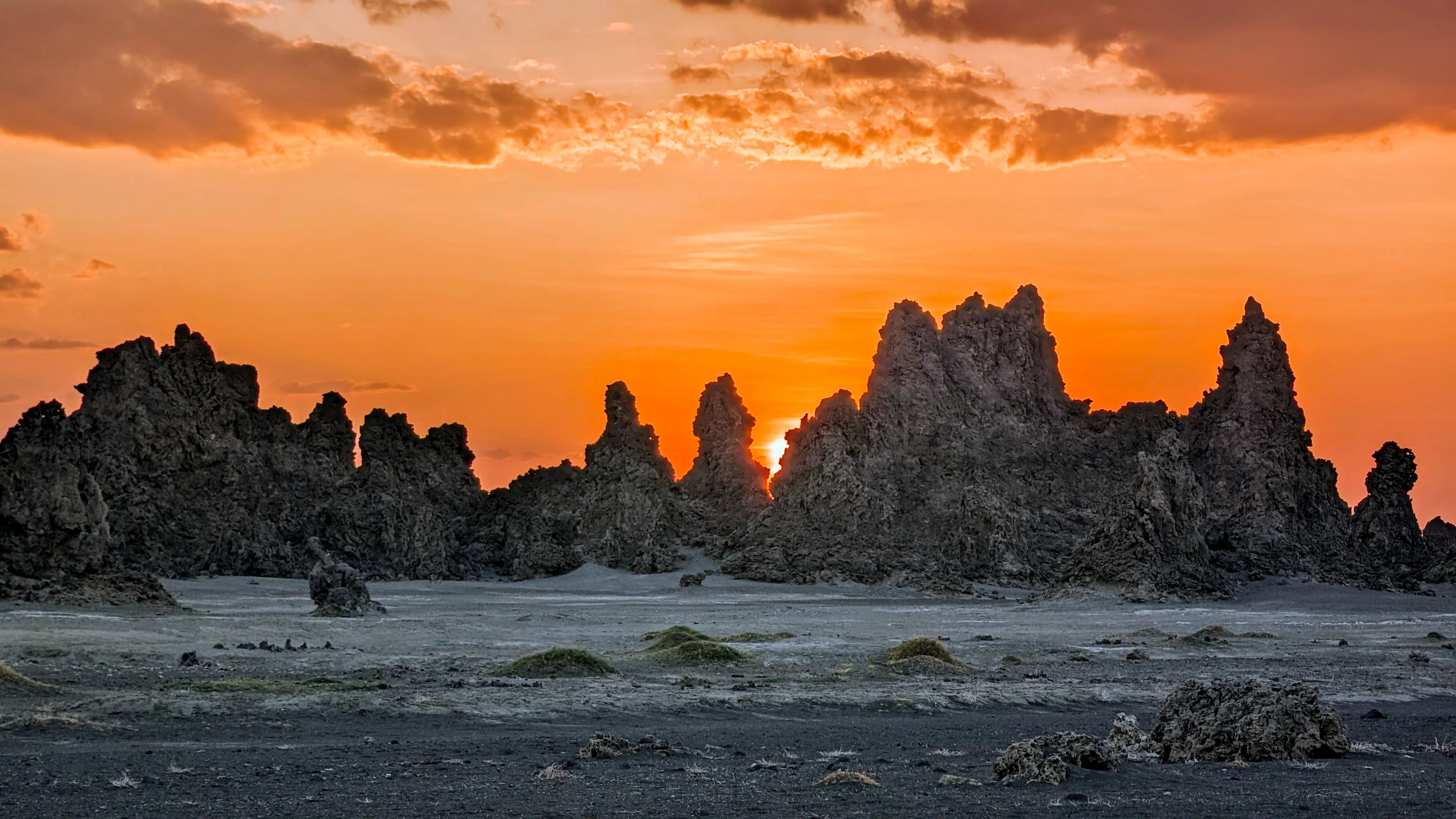 Jagged limestone chimneys silhouetted against fiery orange sunrise at Djibouti’s Lake Abbe.