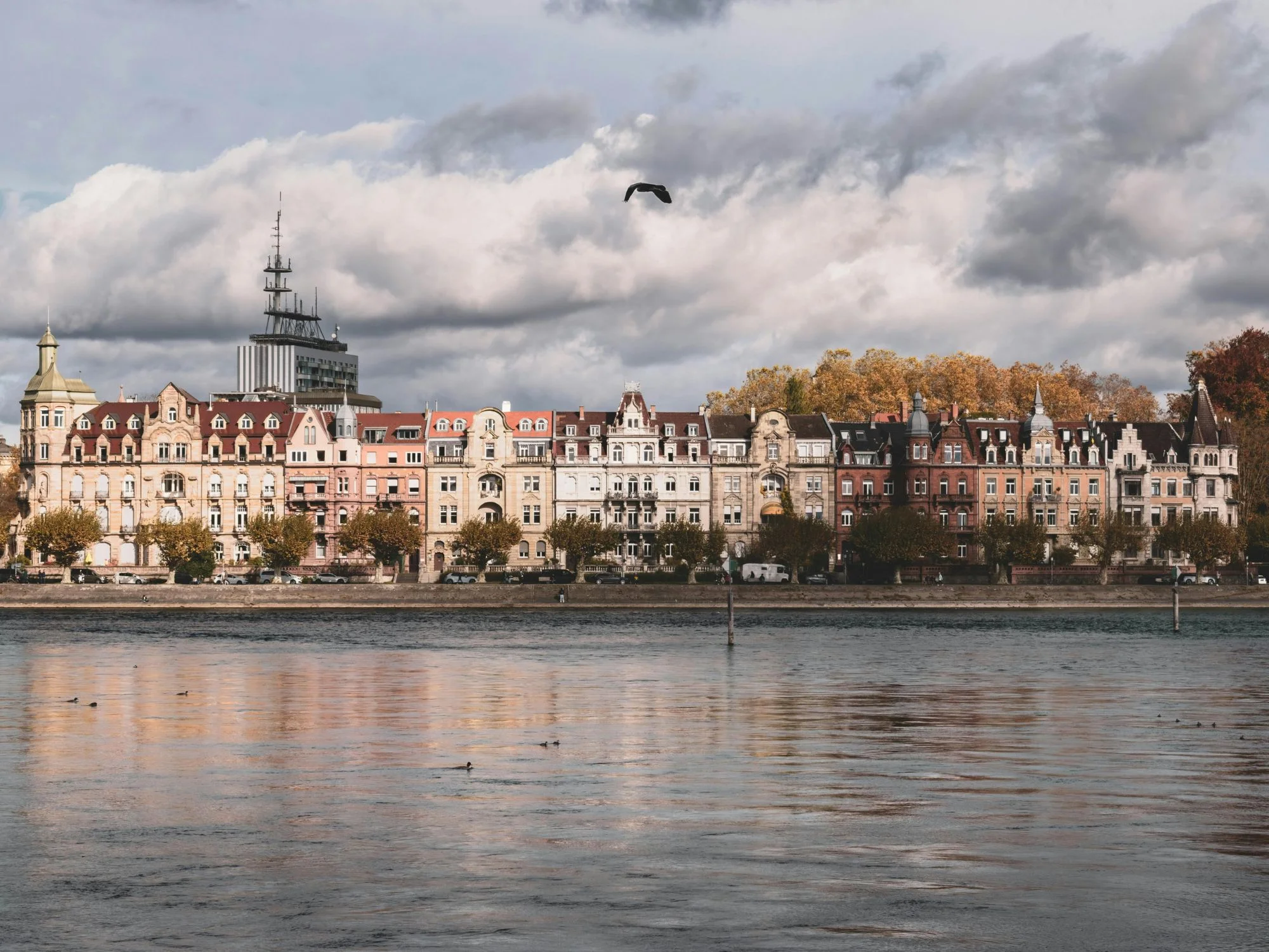 Pastel historic waterfront mansions of Constanța, Romania, viewed across the Black Sea on a moody day
