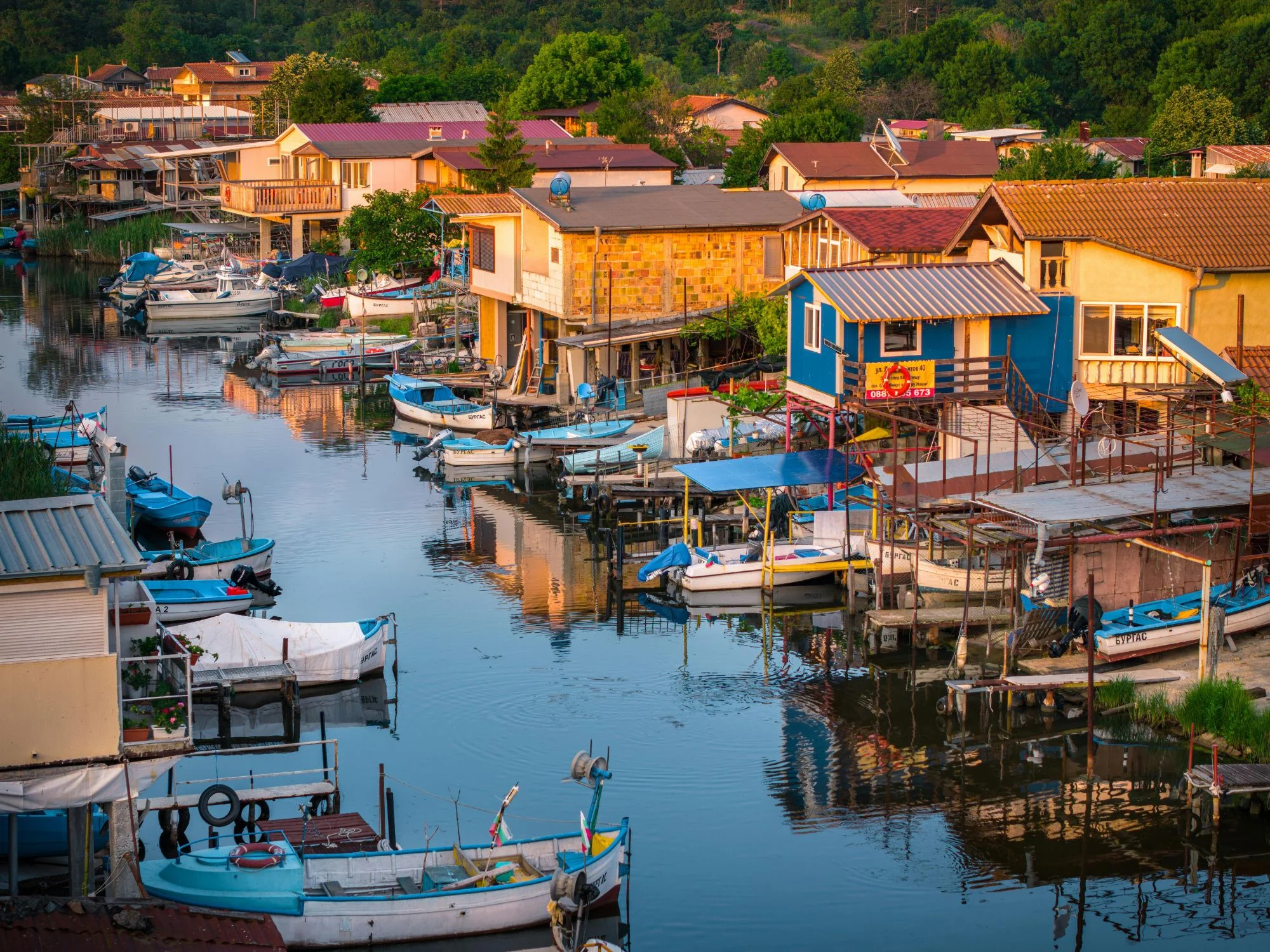Bulgarian Black Sea fishing village with stilted wooden boat-houses and small fishing boats in a calm harbour