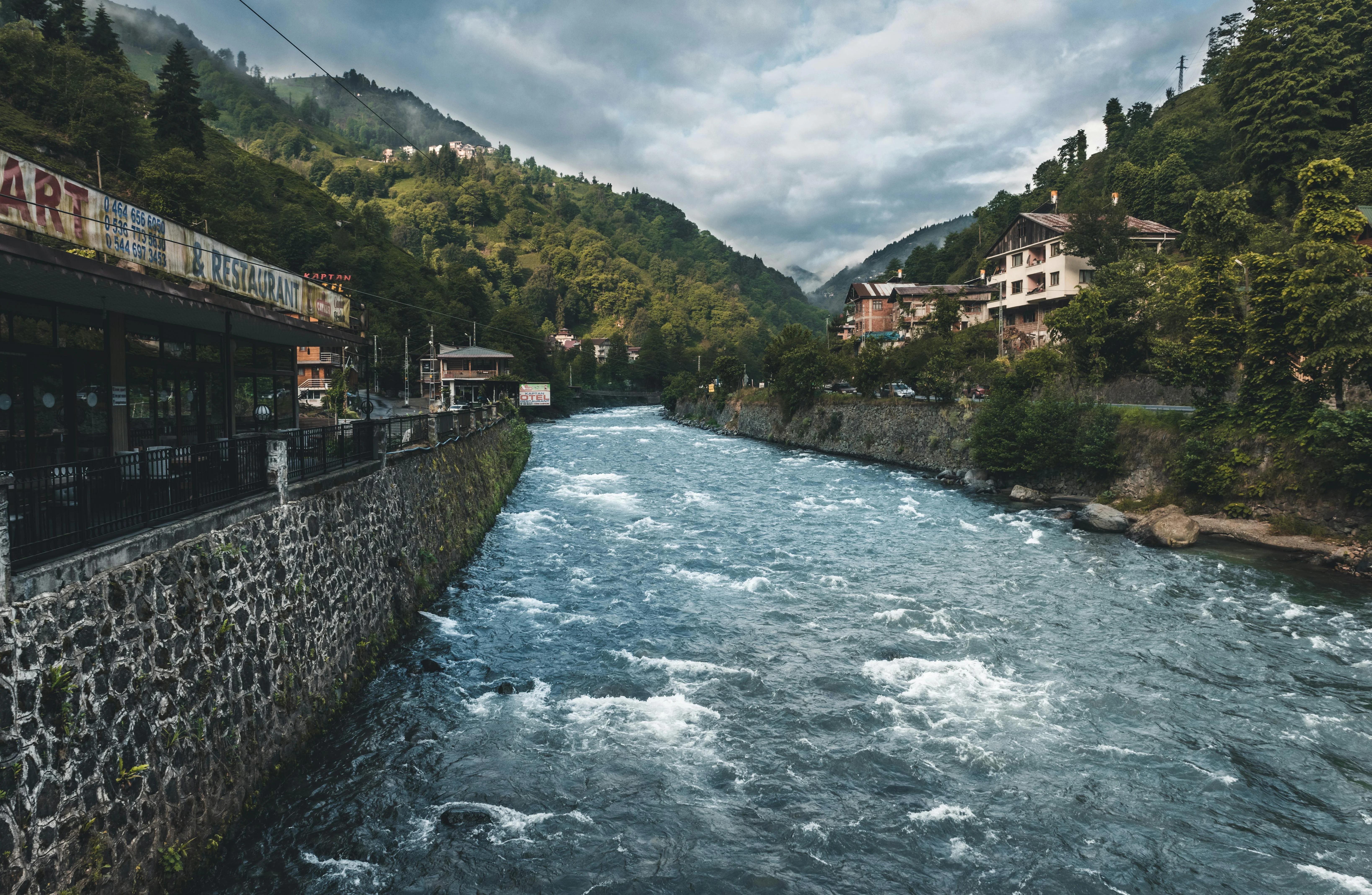 Fast-flowing mountain river through a forested Black Sea valley in north-east Turkey, with riverside houses