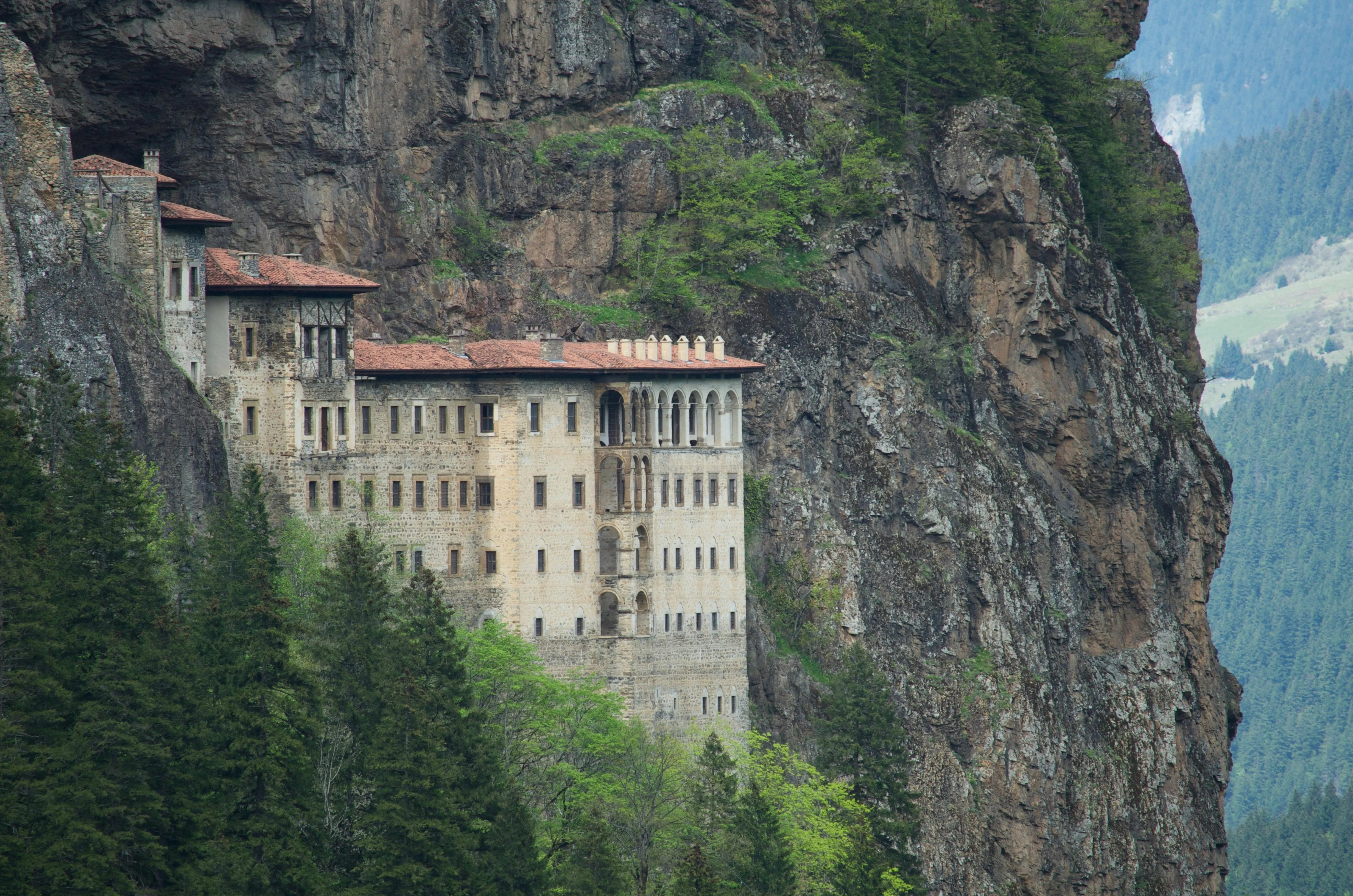Sumela Monastery's stone walls built into the cliff face above forested slopes near Trabzon, Turkey