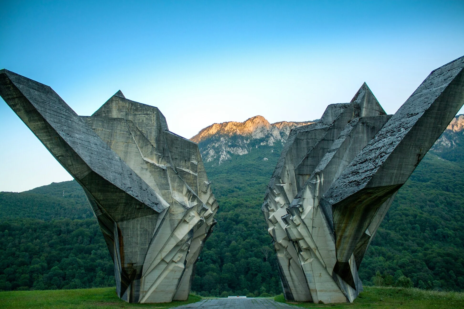 Tjentište war memorial concrete monument set against forested mountains in Sutjeska National Park, Bosnia