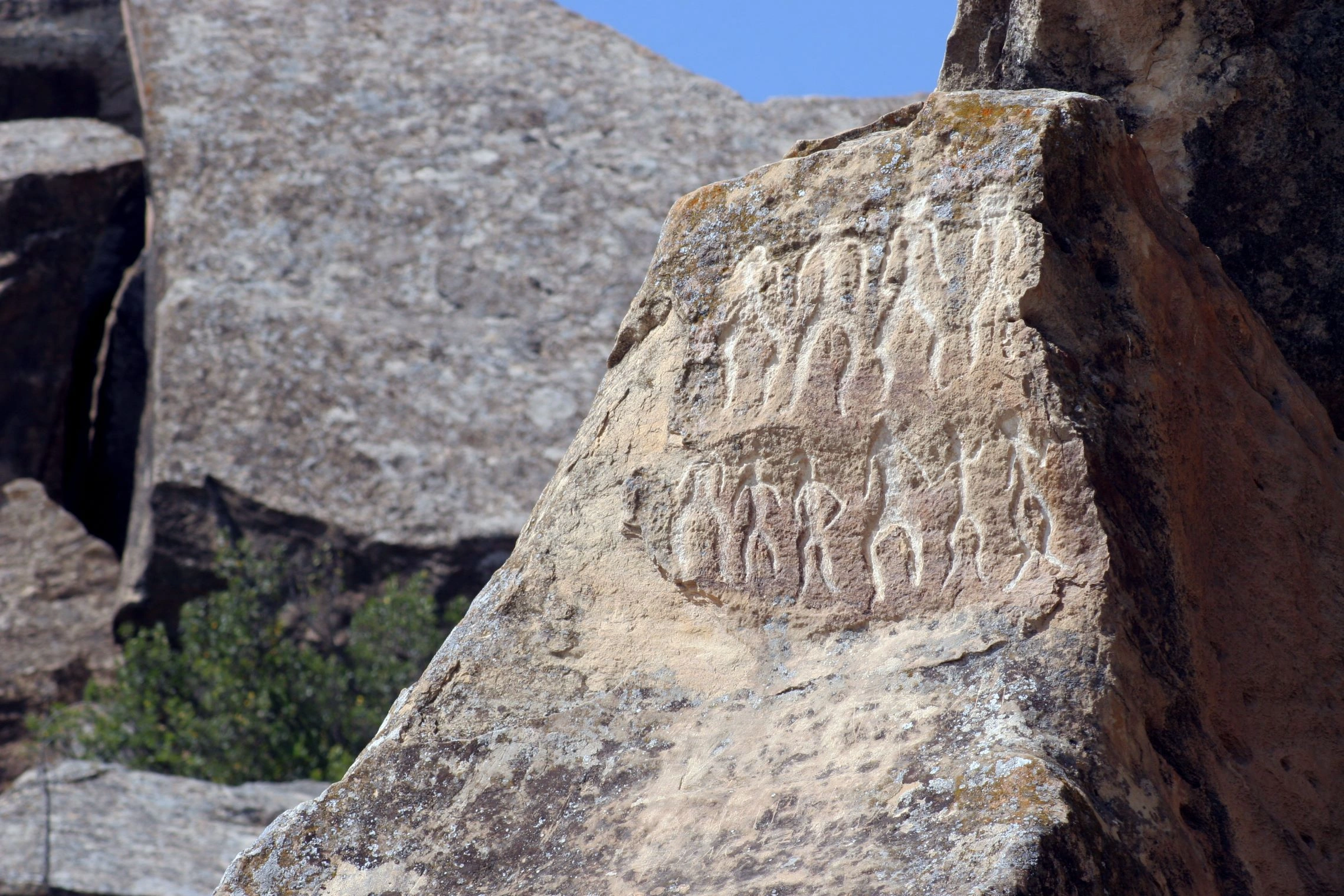 Prehistoric petroglyphs of human figures carved into a sandstone boulder at Gobustan National Park, Azerbaijan