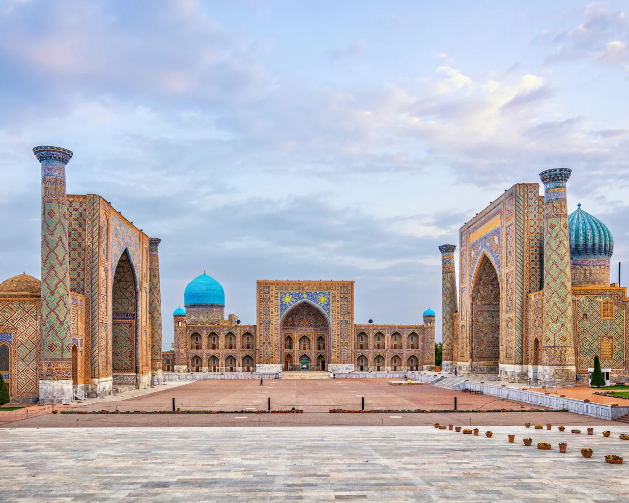 Registan Square with three tiled madrasahs lit by sunrise light, Samarkand, Uzbekistan